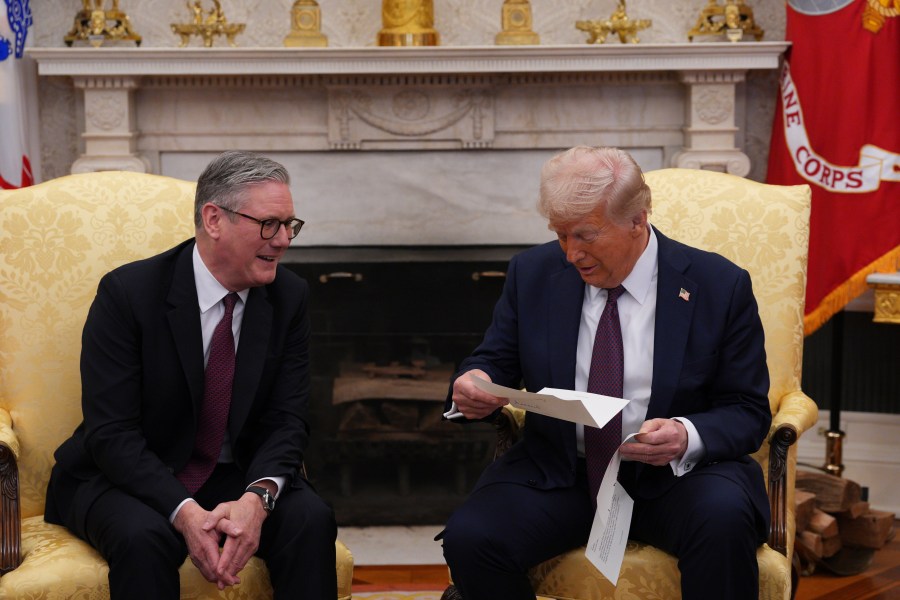 FILE - British Prime Minister Keir Starmer, left, hands an invitation from King Charles III for a second state visit to President Donald Trump at the White House, Thursday, Feb. 27, 2025, in Washington. (Carl Court/Pool via AP, File)