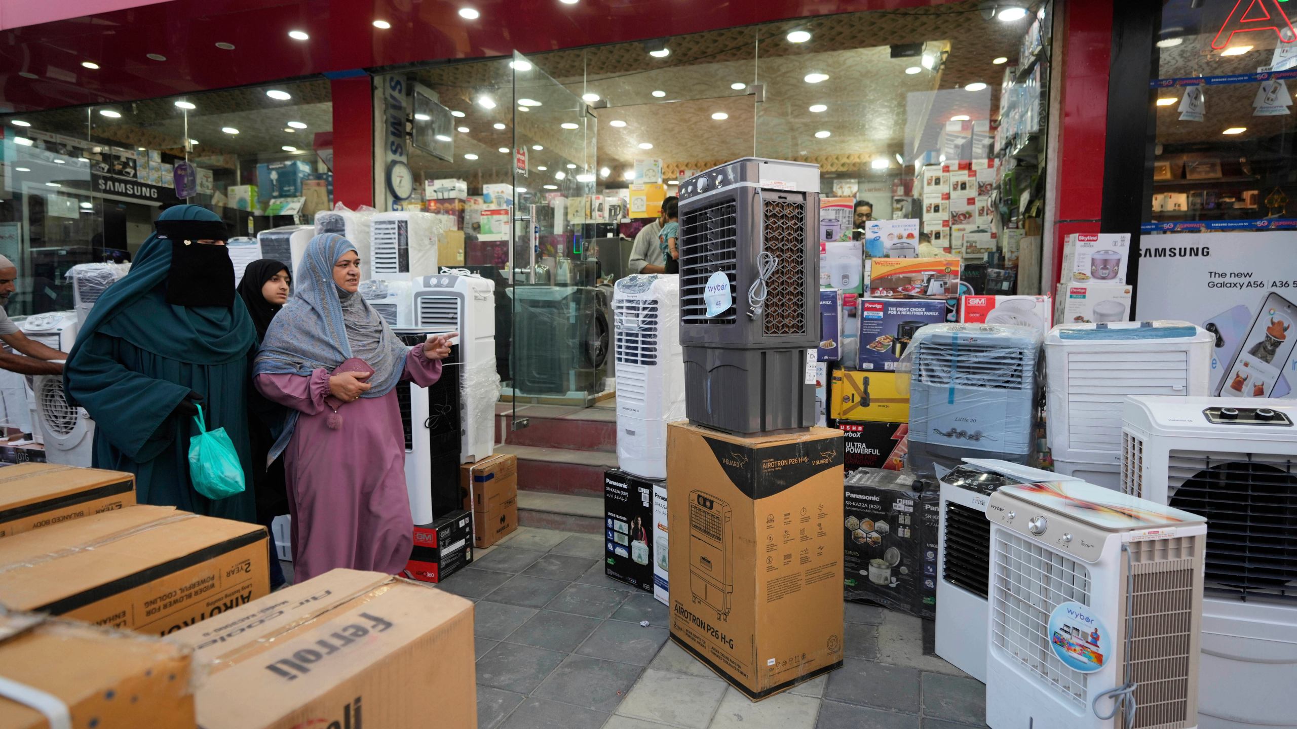 FILE - People purchase air conditioners at a shop on a hot summer day in Srinagar, Indian-controlled Kashmir, June 24, 2025. (AP Photo/Mukhtar Khan, File)