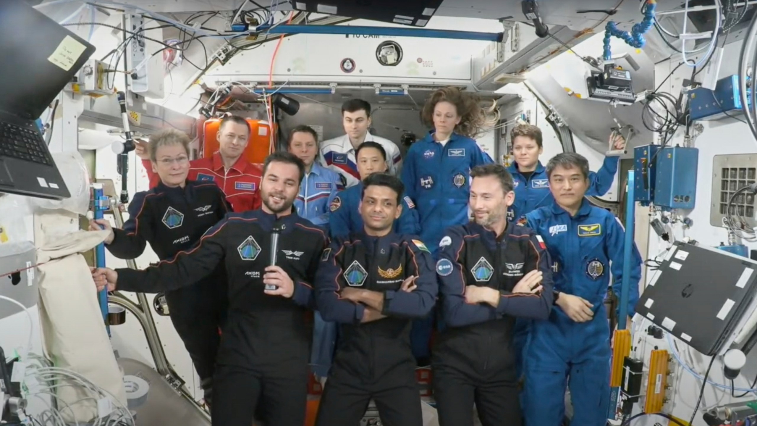 This photo provided by Axiom Space shows the private crew of four, in dark suits, from left, Axiom mission commander Peggy Whitson, Hungary's Tibor Kapu, India's Shubhanshu Shukla and Poland's Slawosz Uznanski-Wisniewski, during a farewell ceremony aboard the International Space Station on Sunday, July 13, 2025. (Axiom Space via AP)