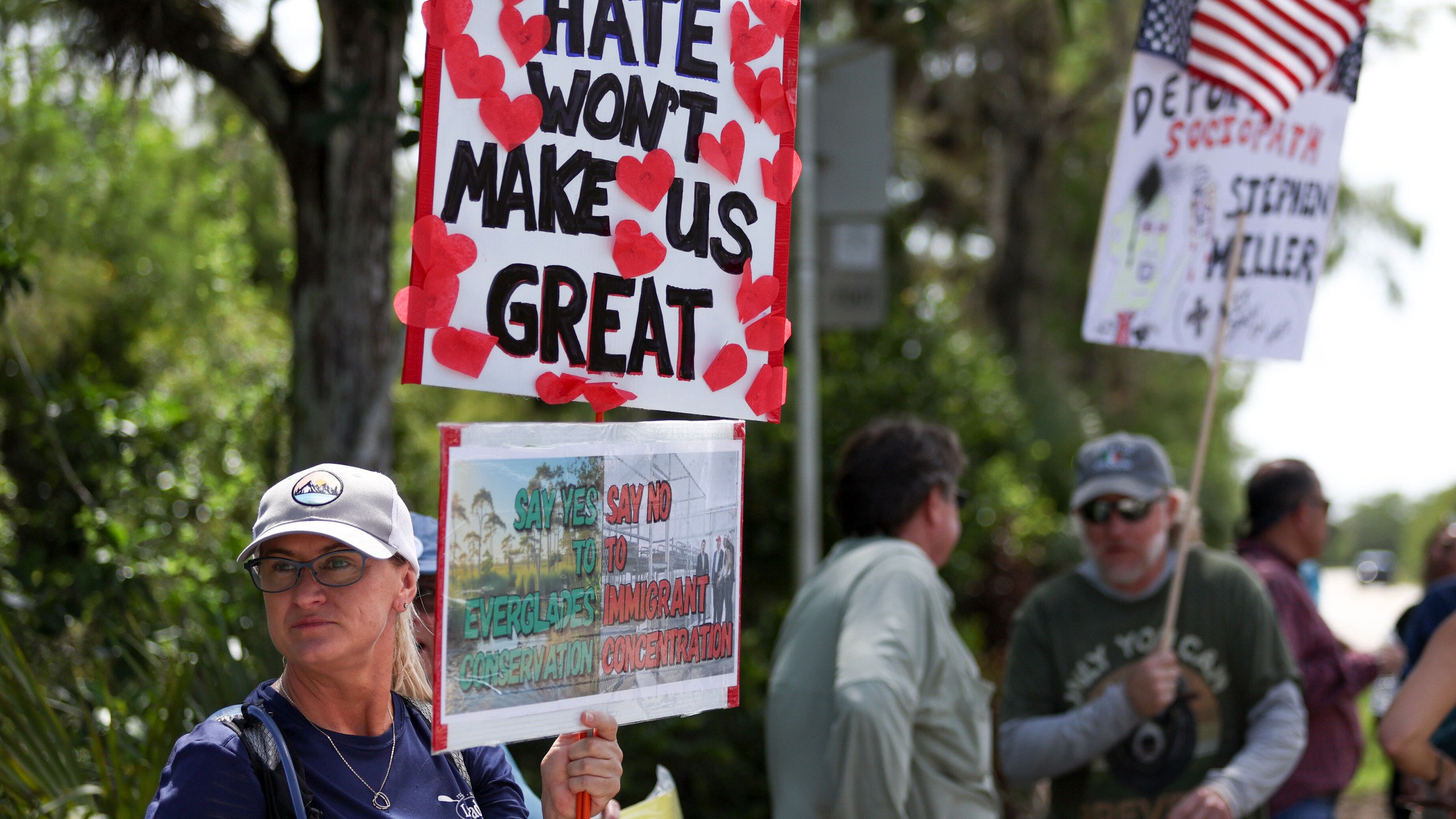 A protester stands outside the migrant detention facility dubbed "Alligator Alcatraz" at the Dade-Collier Training and Transition Facility, Saturday, July 12, 2025, in Ochopee, Fla. (AP Photo/Alexandra Rodriguez)