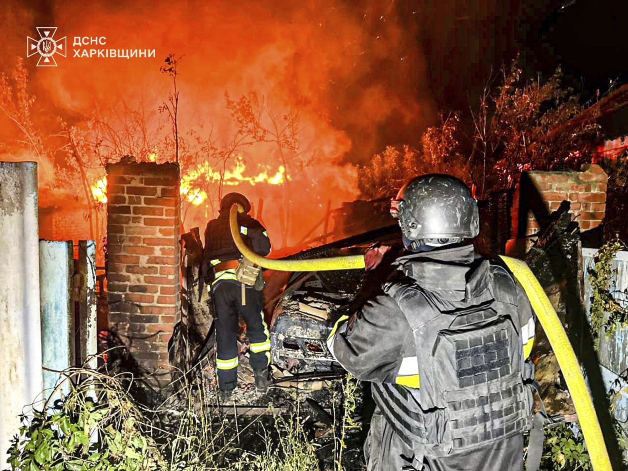In this photo provided by the Ukrainian Emergency Service, firefighters try to put out a fire following a Russian attack in Kharkiv region, Ukraine, Tuesday, July 15, 2025. (Ukrainian Emergency Service via AP)