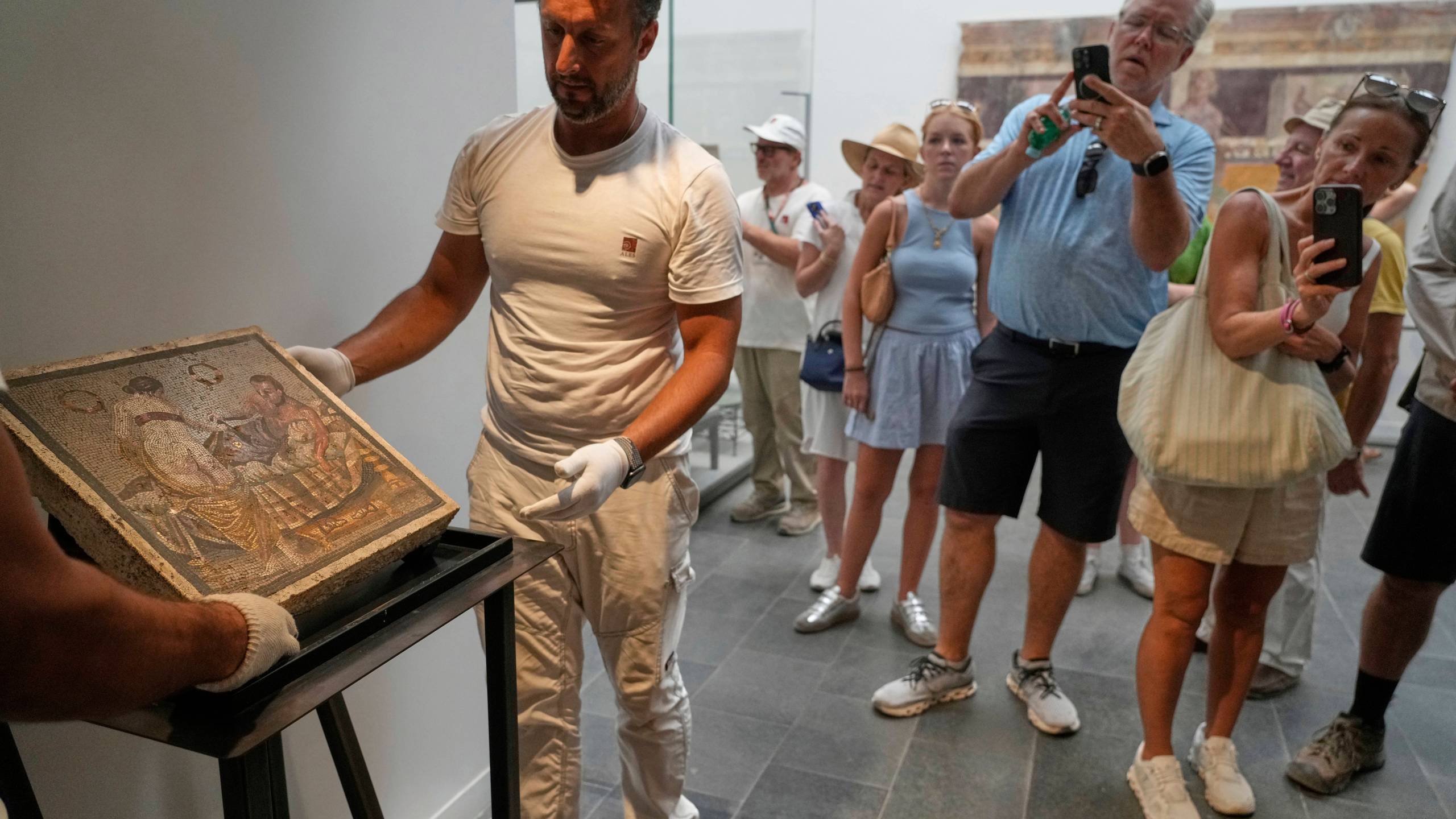 Restorers set on display a Roman mosaic depicting a pair of lovers, which was repatriated from Germany, in Pompeii archaeological park, Italy, Tuesday, July 15, 2025. (AP Photo/Gregorio Borgia)