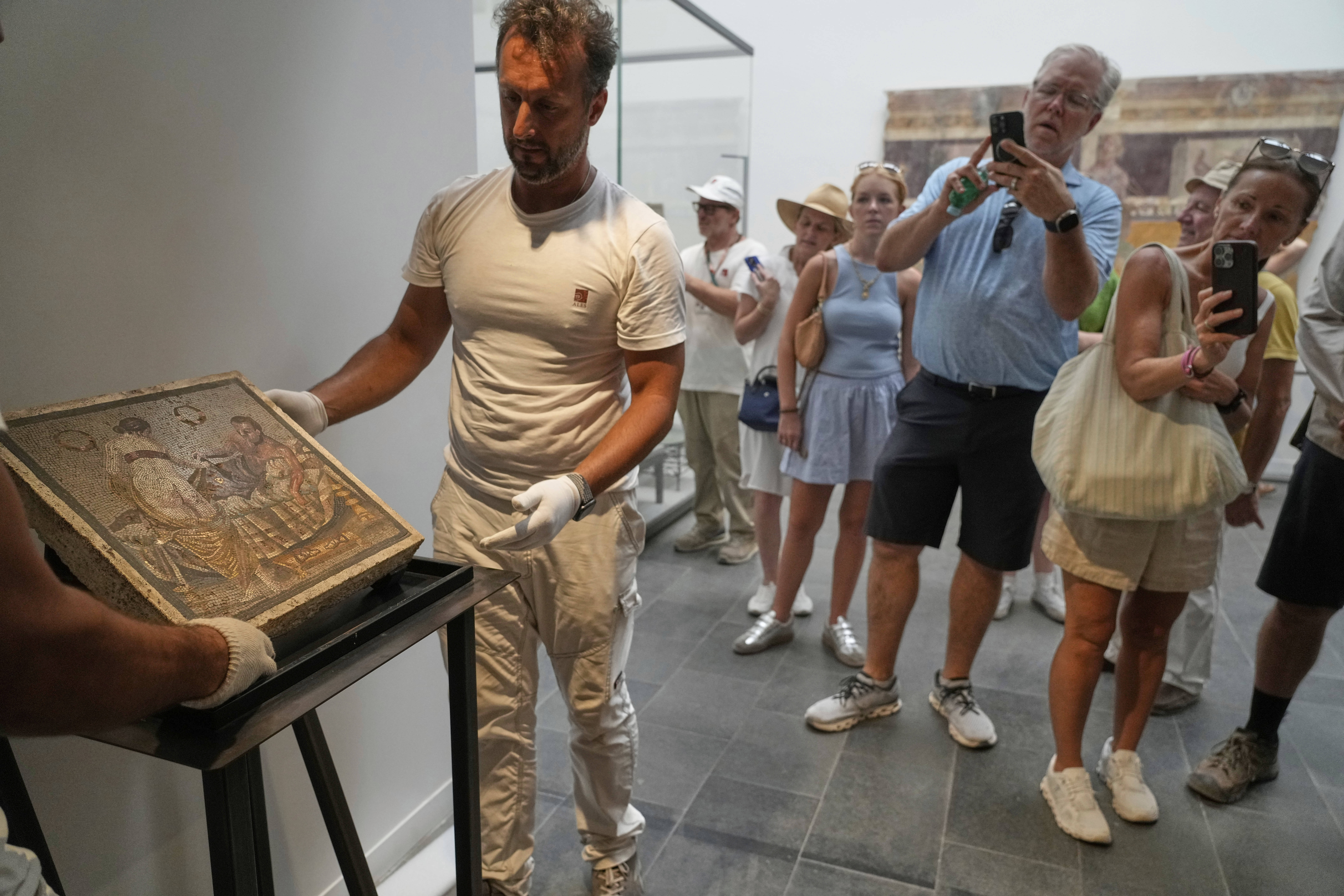Restorers set on display a Roman mosaic depicting a pair of lovers, which was repatriated from Germany, in Pompeii archaeological park, Italy, Tuesday, July 15, 2025. (AP Photo/Gregorio Borgia)