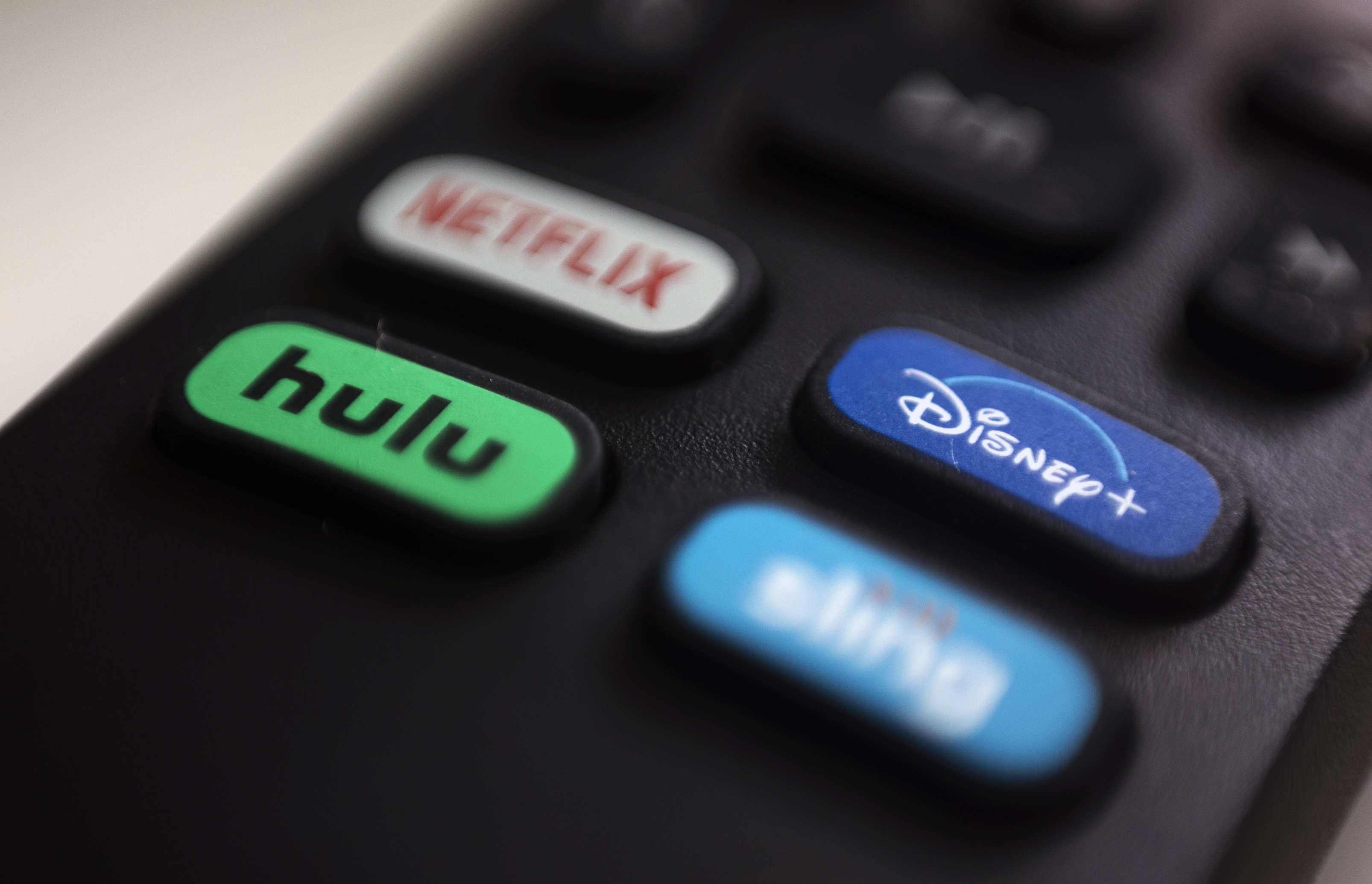FILE - The logos for streaming services Netflix, Hulu, Disney Plus and Sling TV are pictured on a remote control on Aug. 13, 2020, in Portland, Ore. (AP Photo/Jenny Kane, File)