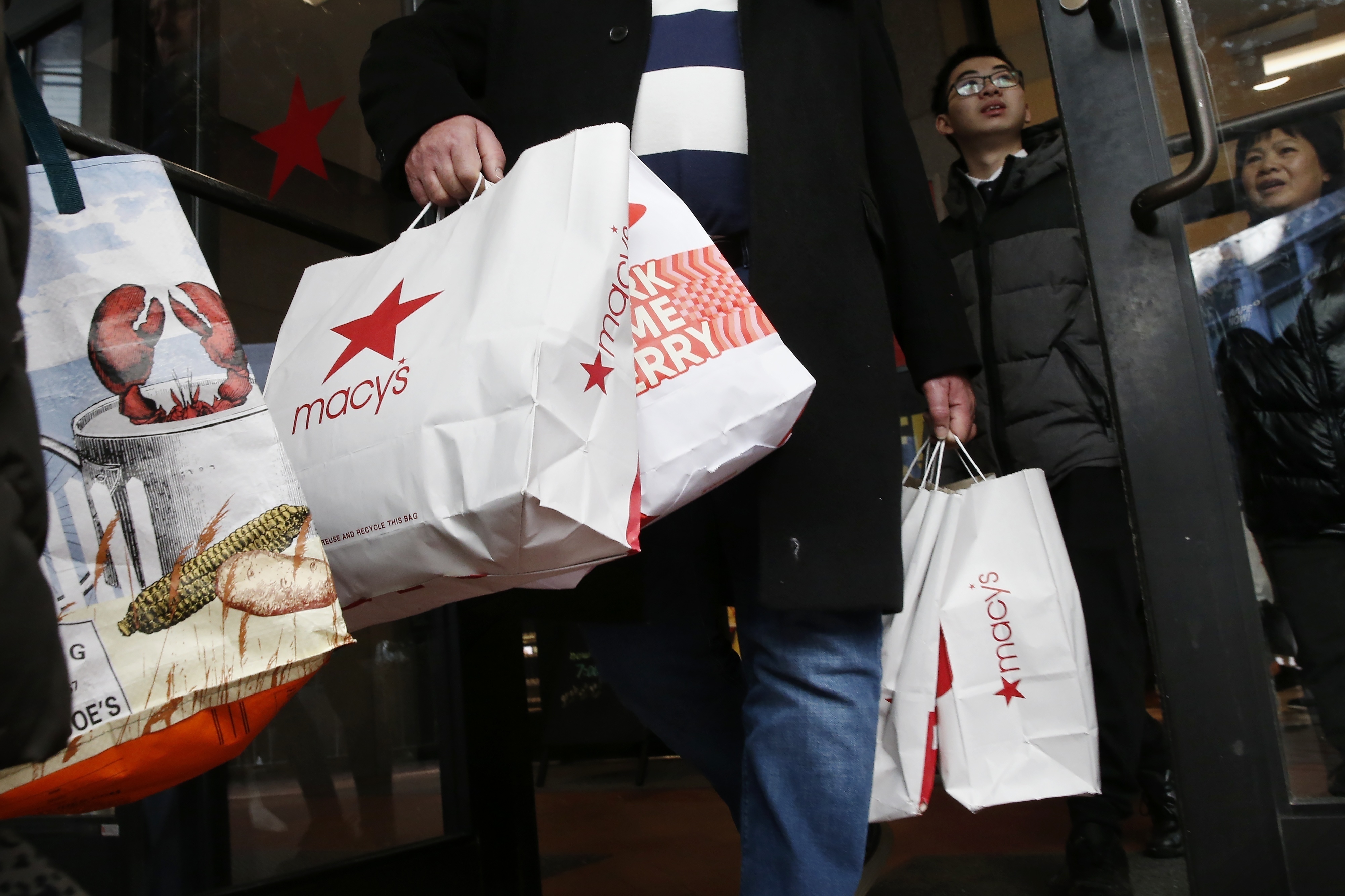 FILE - Shoppers leave Macy's in Boston, Nov. 29, 2019. (AP Photo/Michael Dwyer, file)
