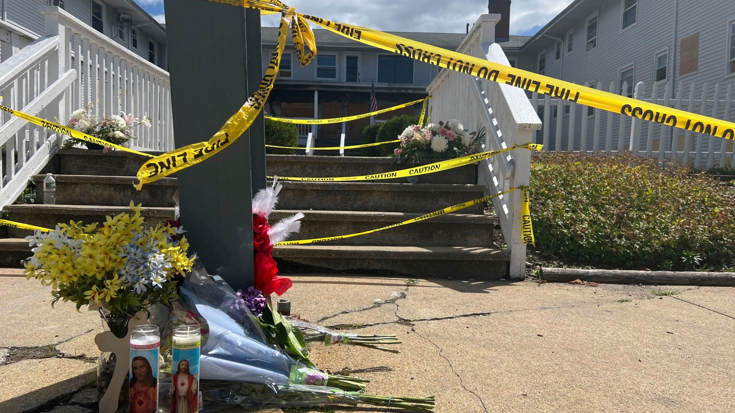 Flowers and candles sit in front of the Gabriel House assisted living home, where a fire on Sunday killed several people, Tuesday, July 15, 2025 in Fall River, Mass. (AP Photo/Kimberlee Kruesi)