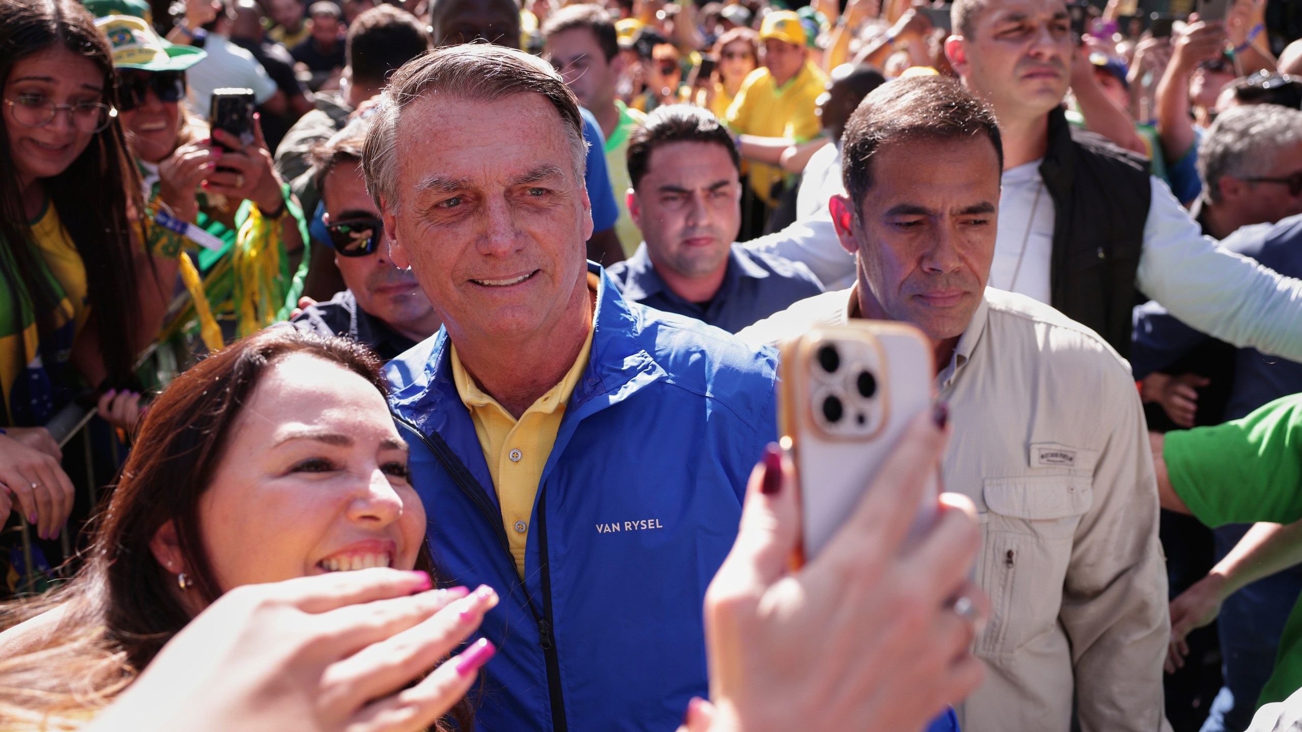 Former President Jair Bolsonaro poses for a selfie with a supporter upon arriving at a protest against his Supreme Court trial, in which he is accused of involvement in a 2022 coup attempt, in Sao Paulo, Sunday, June, 29, 2025. (AP Photo/Ettore Chiereguini)