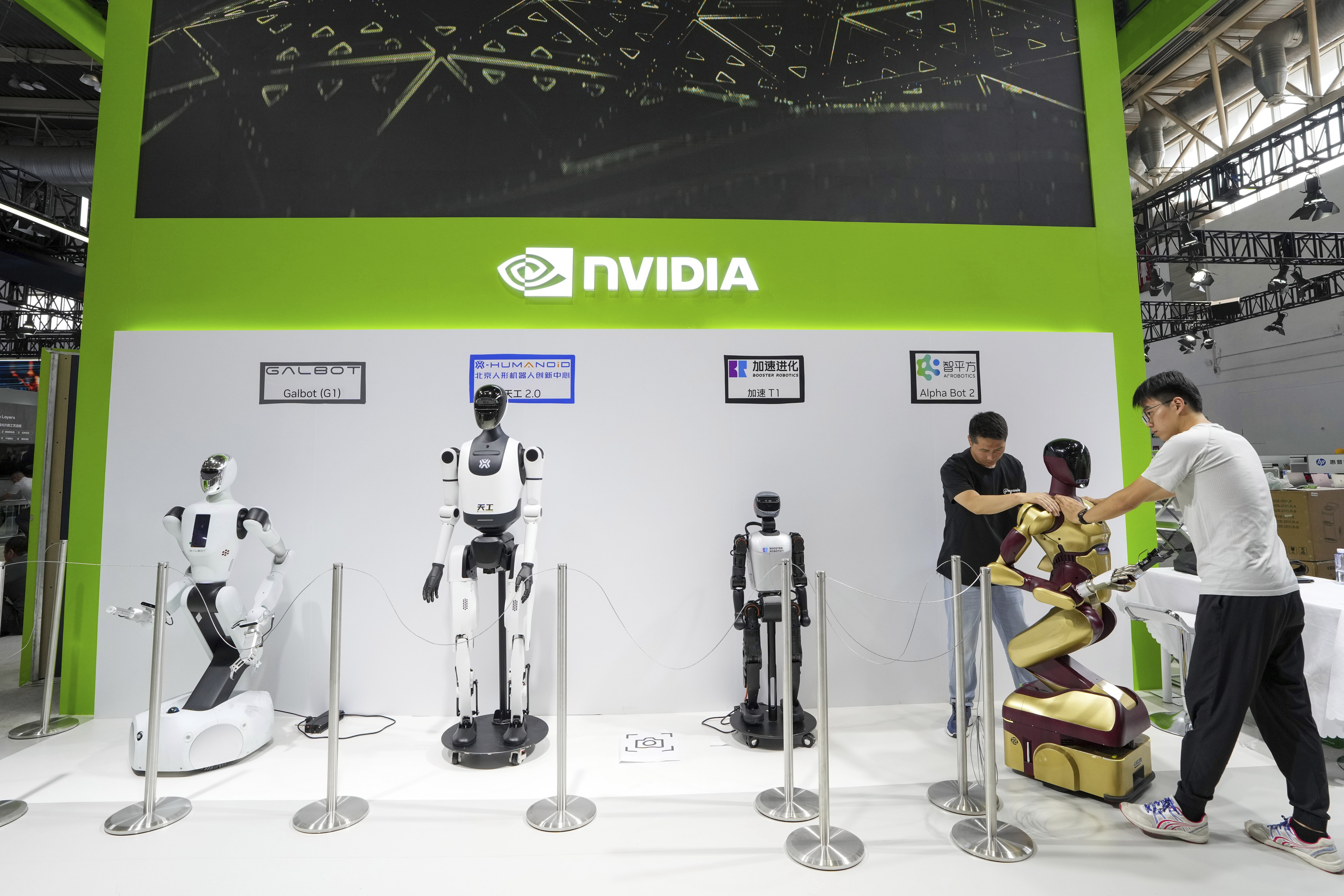 In this photo released by Xinhua News Agency, workers set up a robot at the booth of Nvidia ahead of the upcoming third China International Supply Chain Expo (CISCE) in Beijing, on July 14, 2025. (Ju Huanzong/Xinhua via AP)