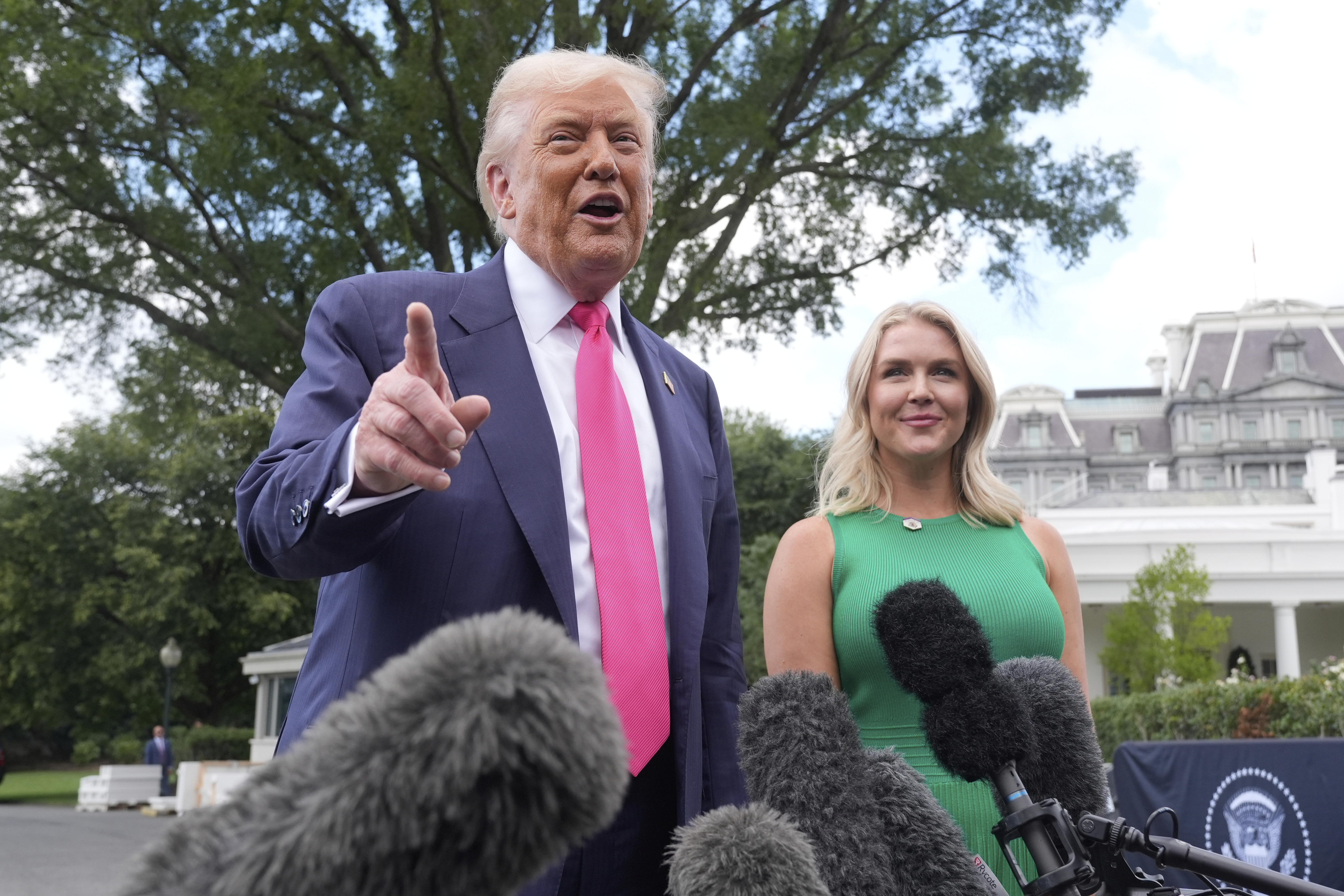 President Donald Trump speaks to the media as he leaves the White House, Tuesday, July 15, 2025, in Washington, as White House press secretary Karoline Leavitt, looks on. (AP Photo/Manuel Balce Ceneta)