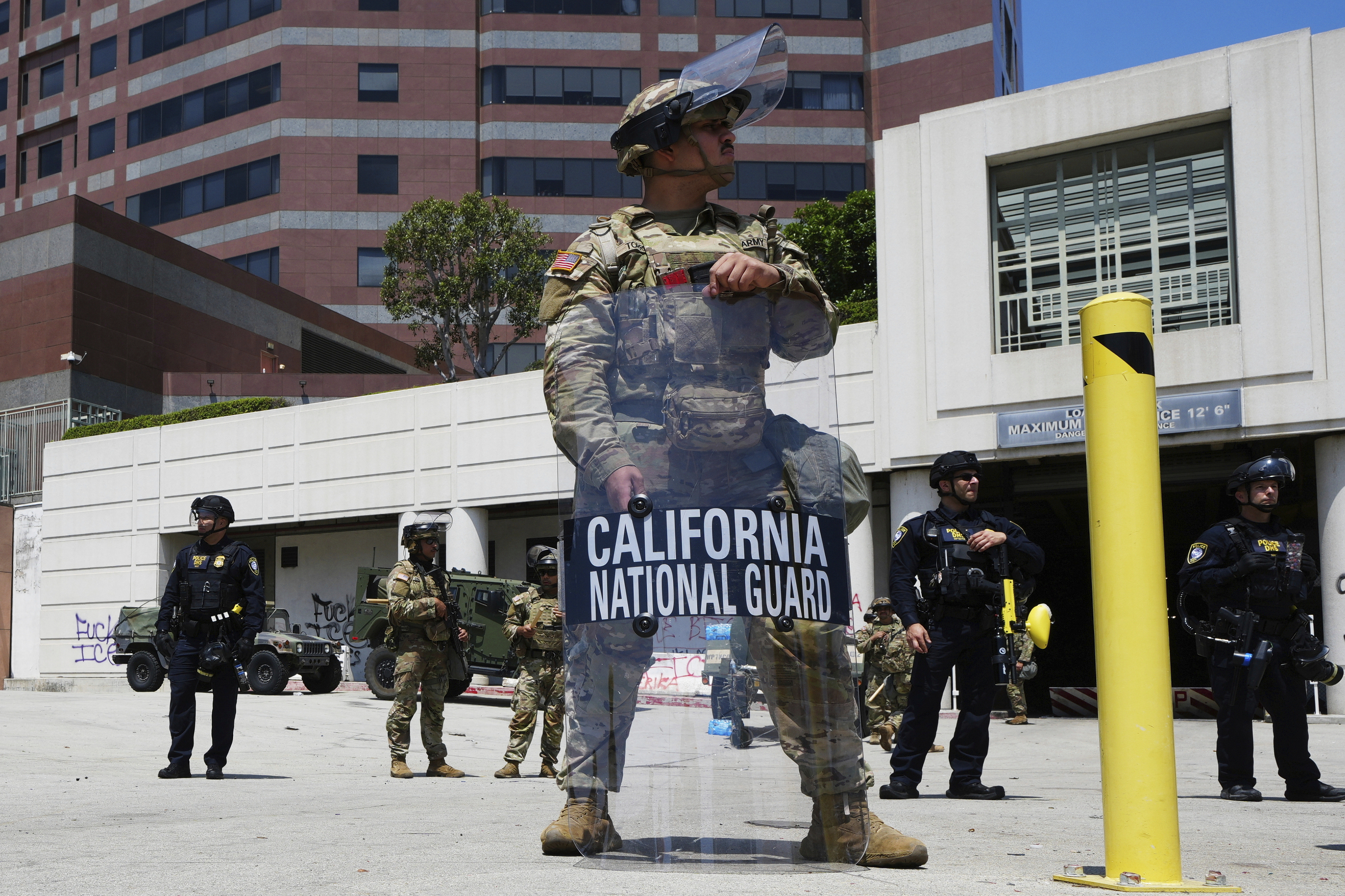 FILE - A California National Guardsmen stands to protect federal buildings, June 10, 2025, in Los Angeles. (AP Photo Damian Dovarganes, File)