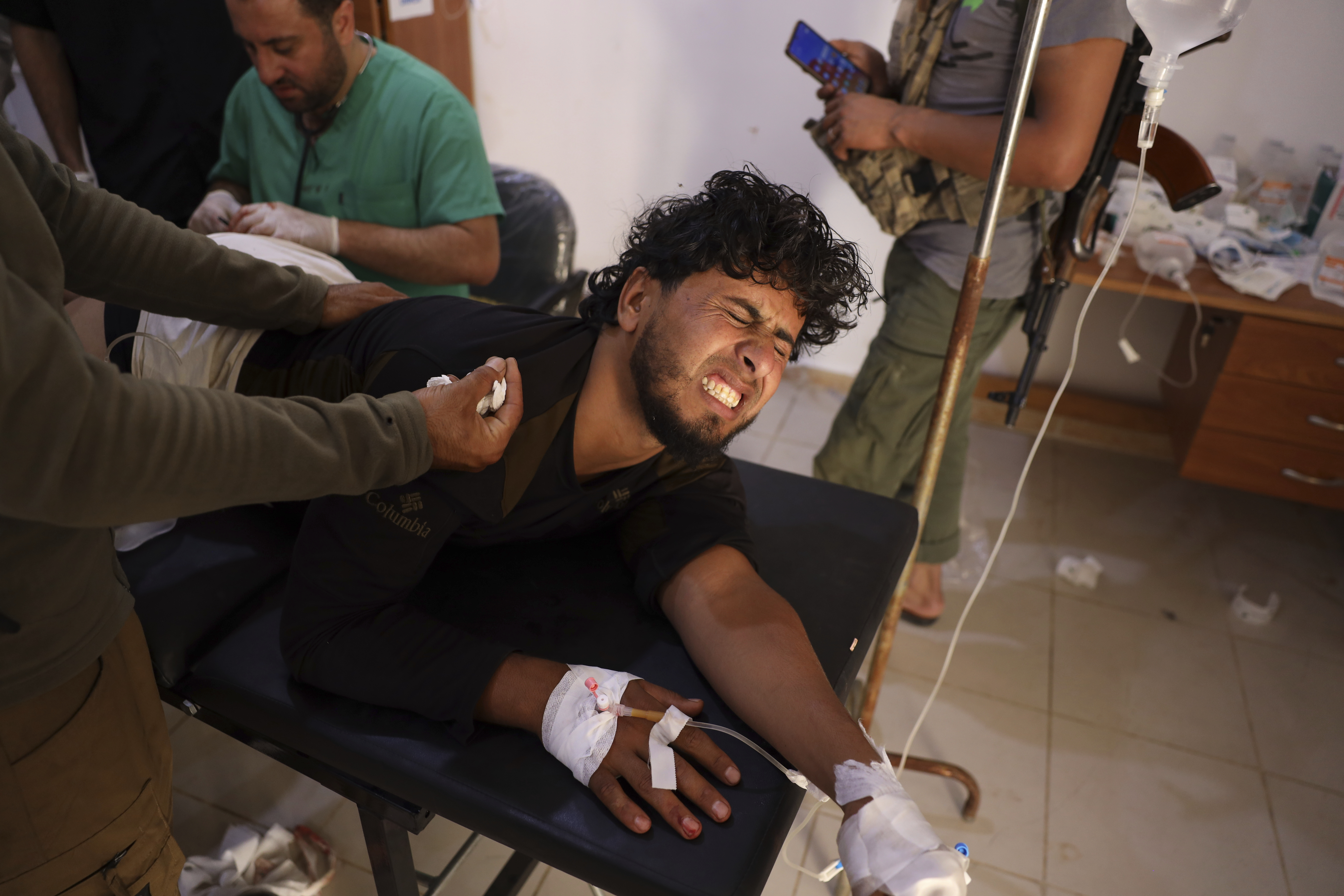 A Syrian government soldier who was injured in Sweida city during clashes between the Syrian government forces and Druze militias, gets treated at a clinic in Busra al-Harir village, in southern Syria, Tuesday, July 15, 2025. (AP Photo/Omar Albam)