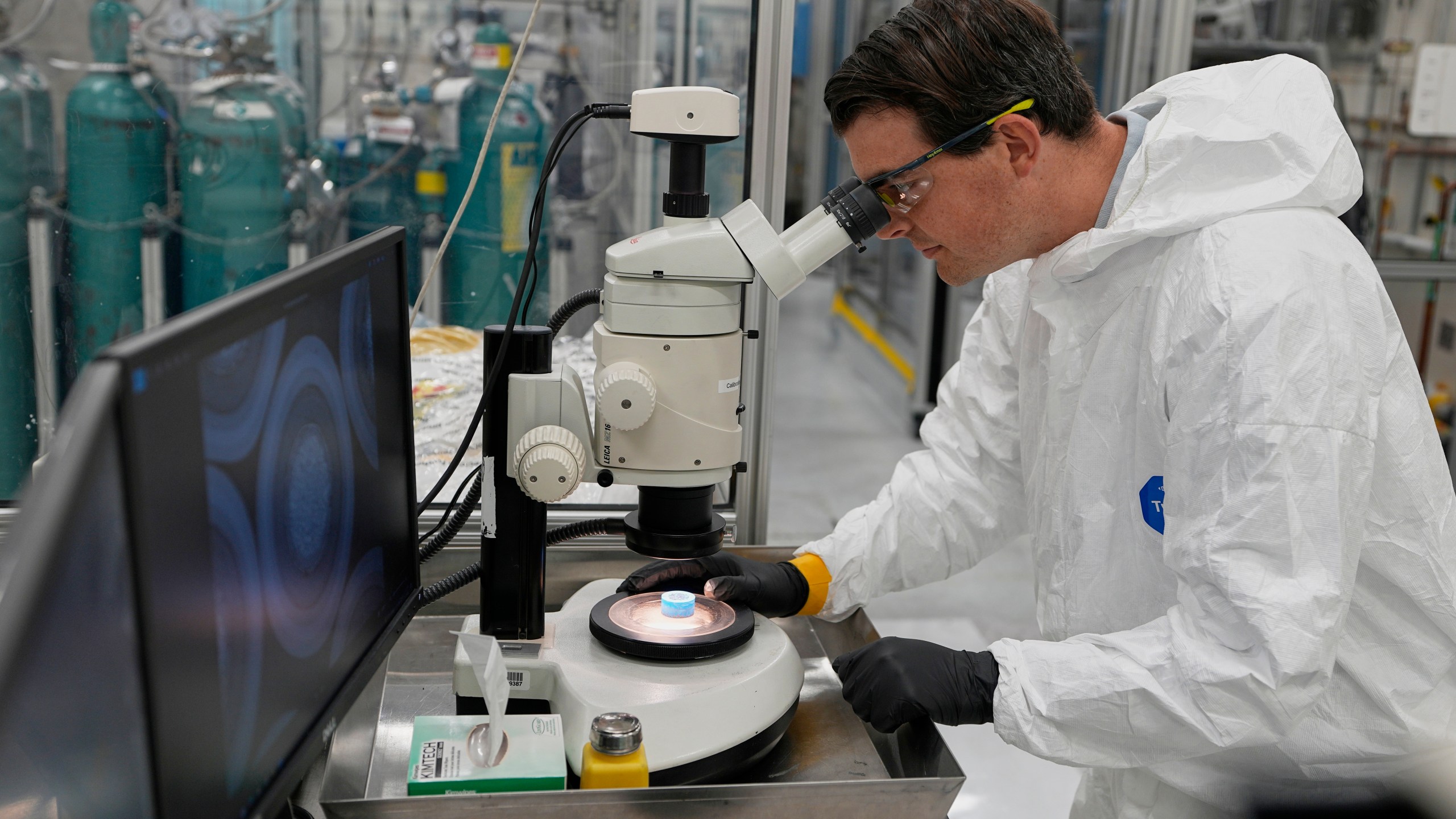 Taylor Duffin, of TRISO-X, a subsidiary of X-Energy, looks at a sample of TRISO fuel through a microscope Friday, June 27, 2025, in Oak Ridge, Tenn. (AP Photo/George Walker IV)