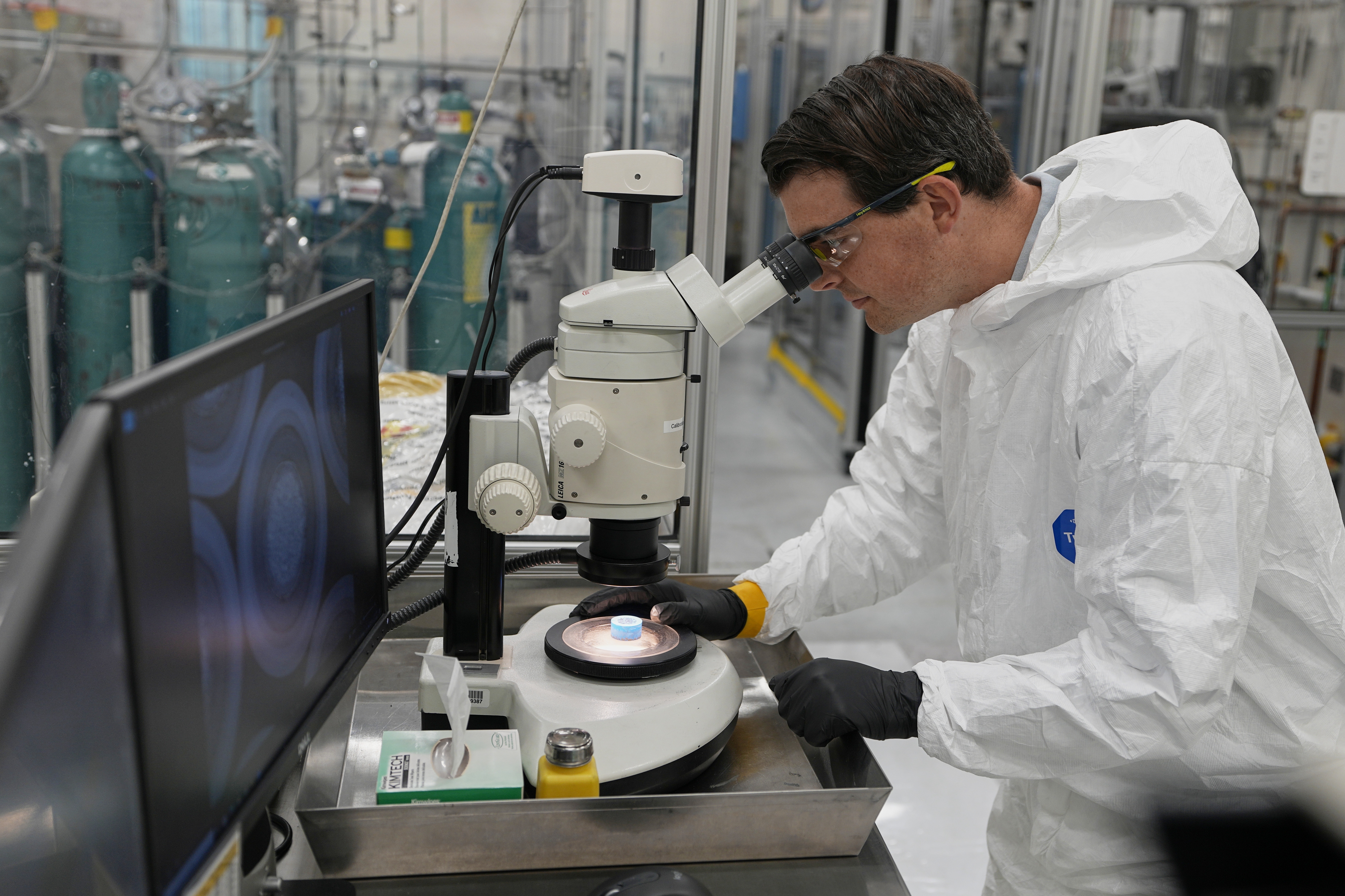 Taylor Duffin, of TRISO-X, a subsidiary of X-Energy, looks at a sample of TRISO fuel through a microscope Friday, June 27, 2025, in Oak Ridge, Tenn. (AP Photo/George Walker IV)