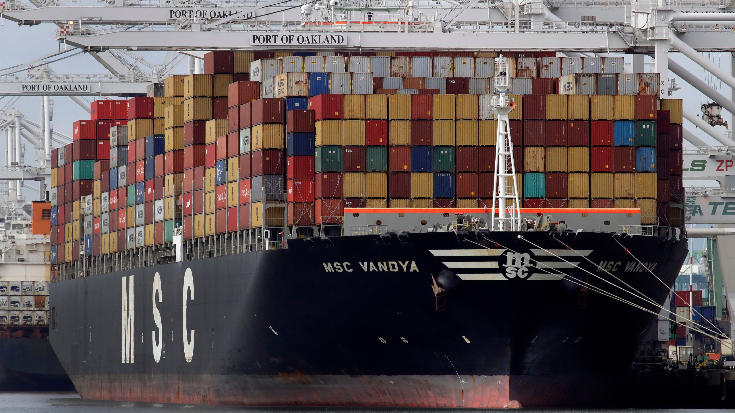 FILE- In this Jan. 28, 2019, file photo a container ship is unloaded at the Port of Oakland in Oakland, Calif. (AP Photo/Ben Margot, File)