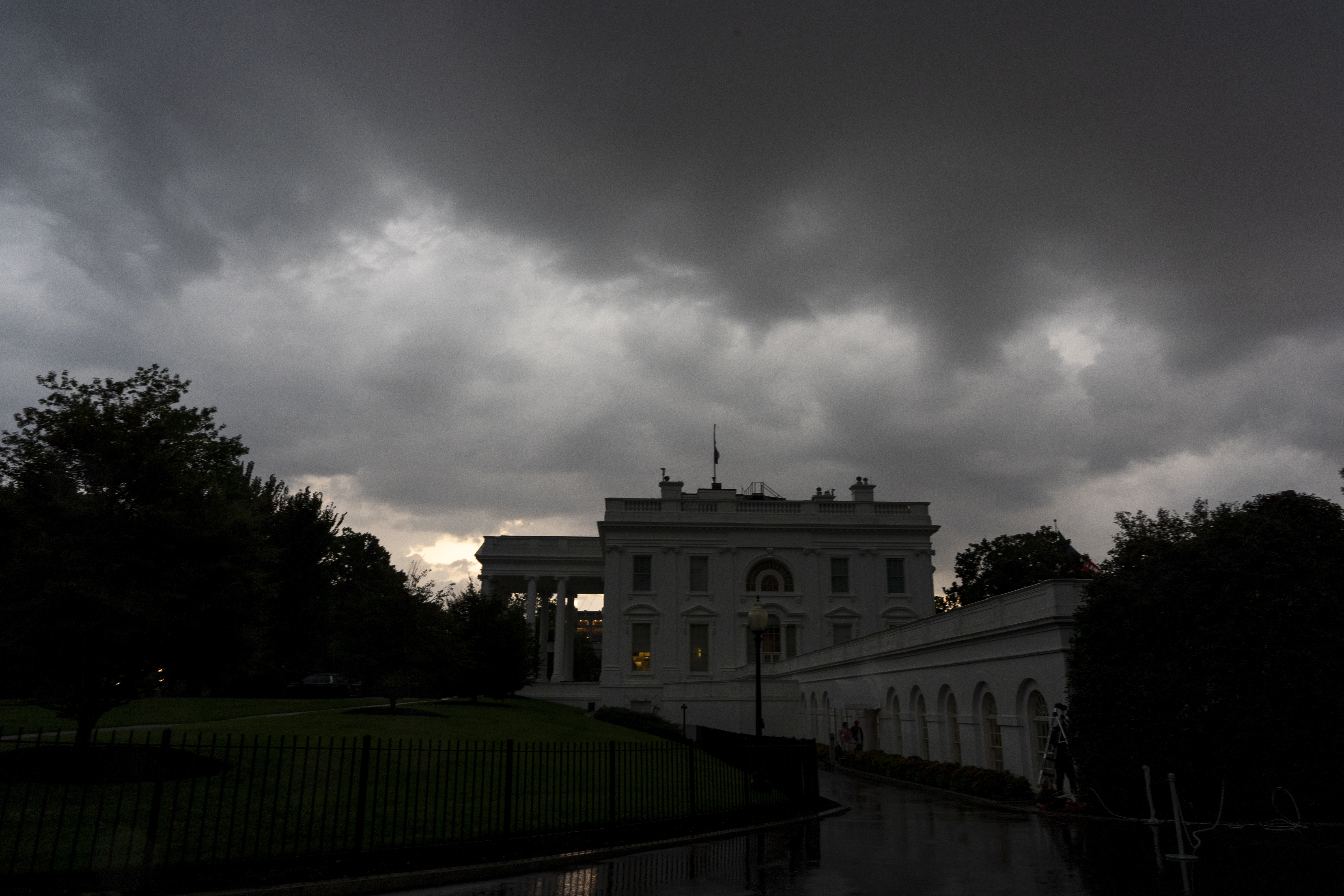 Dark clouds hover over the White House as a front of rain moves through, Monday, July 14, 2025, in Washington. (AP Photo/Alex Brandon)