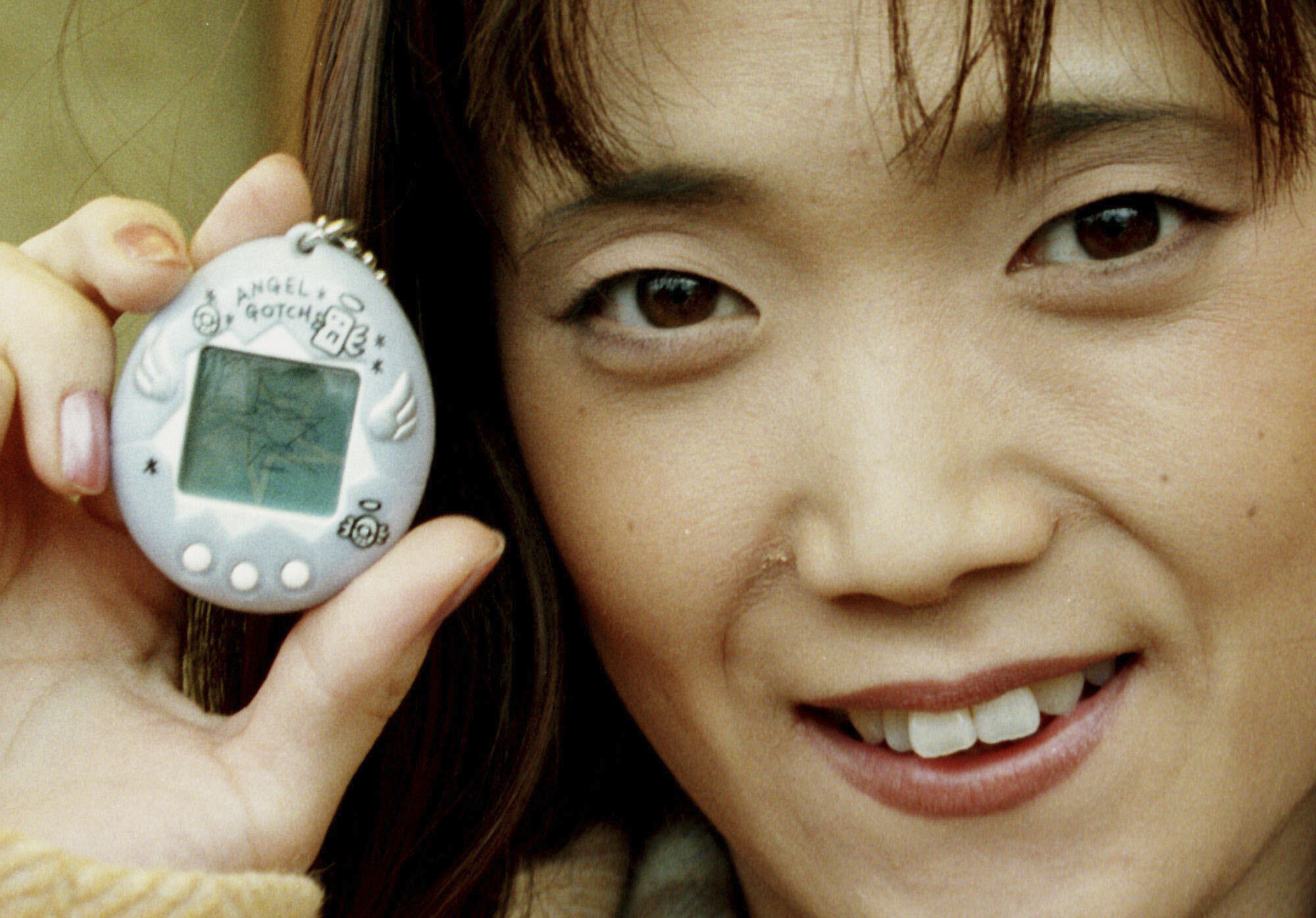 FILE - Aki Maita, Japanese developer of the Tamagotchi digital pet, shows on Monday, December 15, 1997 the new product AngelGotchi after a press conference in Hamburg, Germany. (AP Photo/Oliver Fantitsch, file)