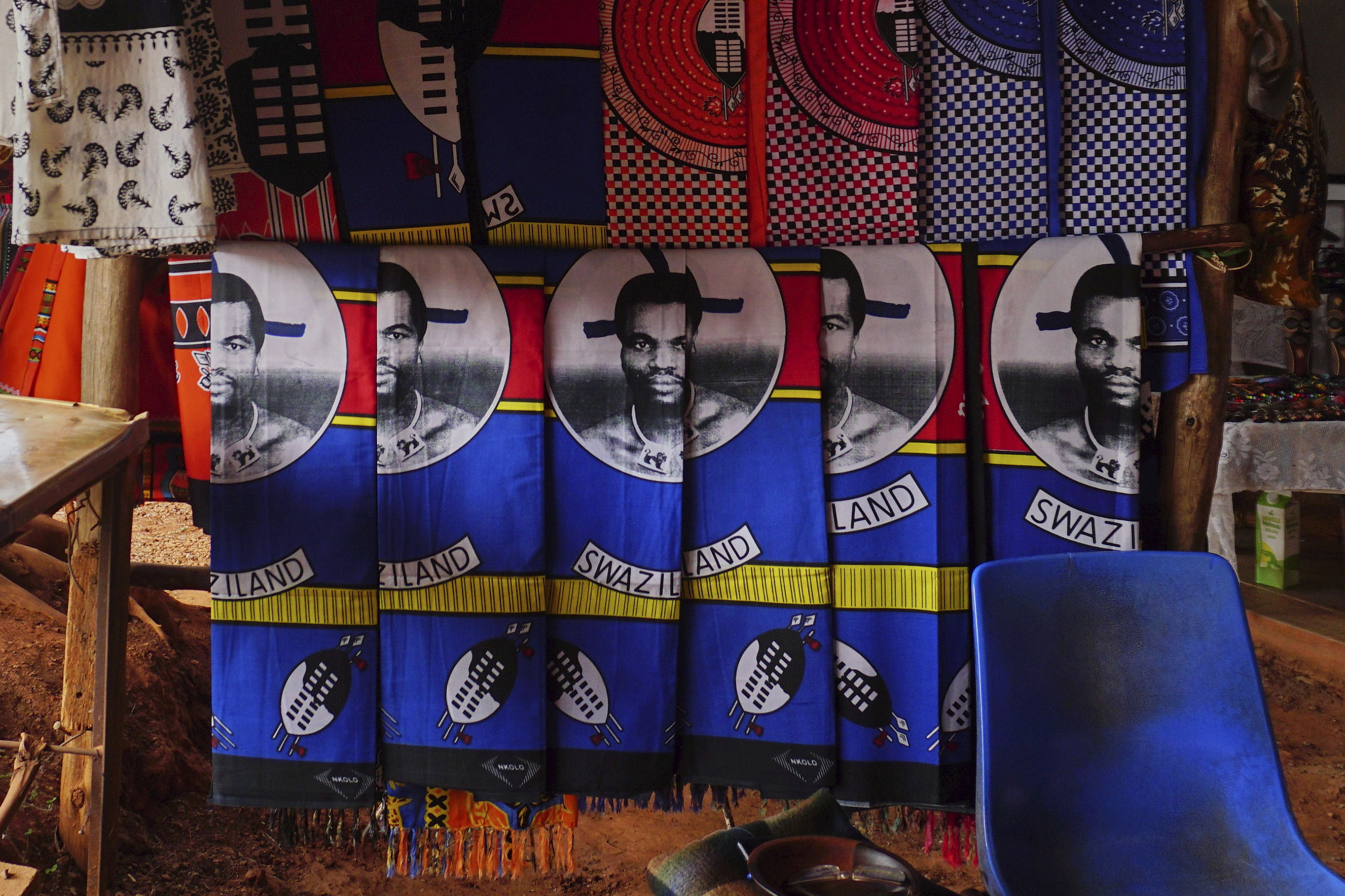 Cloths with King Mswati III's image sit for sale at a market in Lobamba, Eswatini, Friday, Aug. 17, 2018. (AP Photo/Jon Orbach)