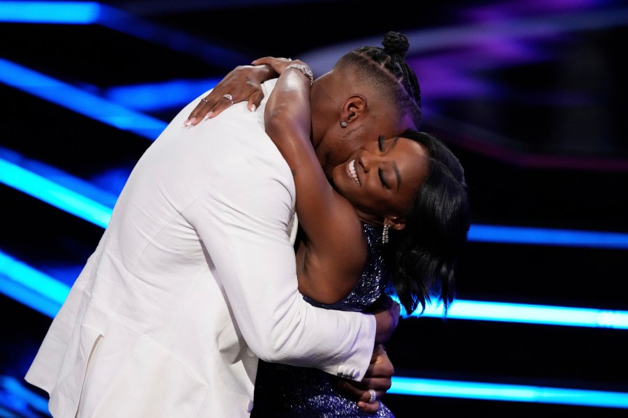 Simone Biles, right, hugs Jonathan Owens while accepting an award at the ESPY Awards at the Dolby Theatre in Los Angeles, Wednesday, July 16, 2025. (AP Photo/Mark J. Terrill)