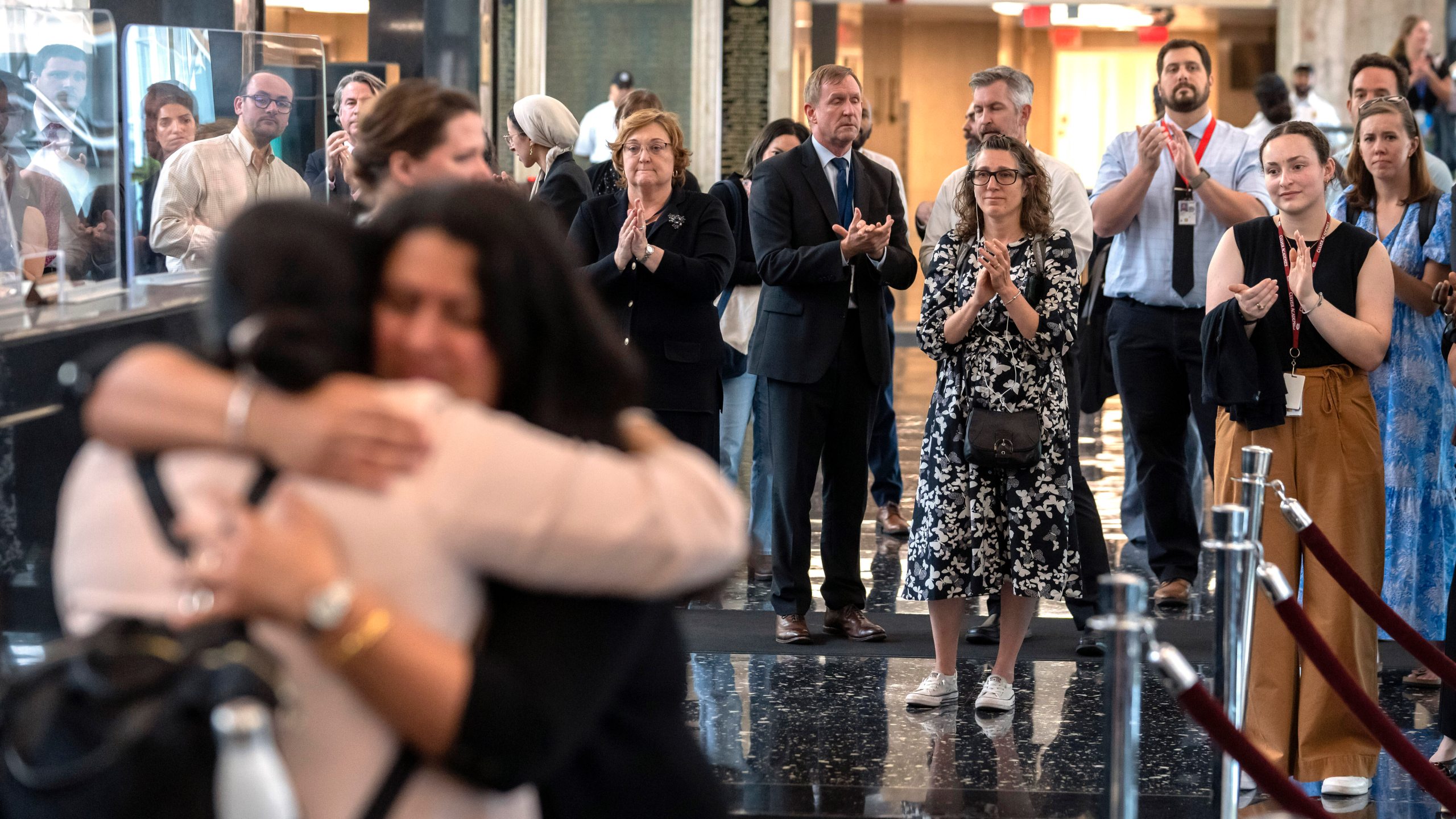 FILE - State Department employees applaud as their colleagues walk through the lobby of the State Department headquarters in the Harry S Truman Building, July 11, 2025, in Washington. (AP Photo/Mark Schiefelbein, File)