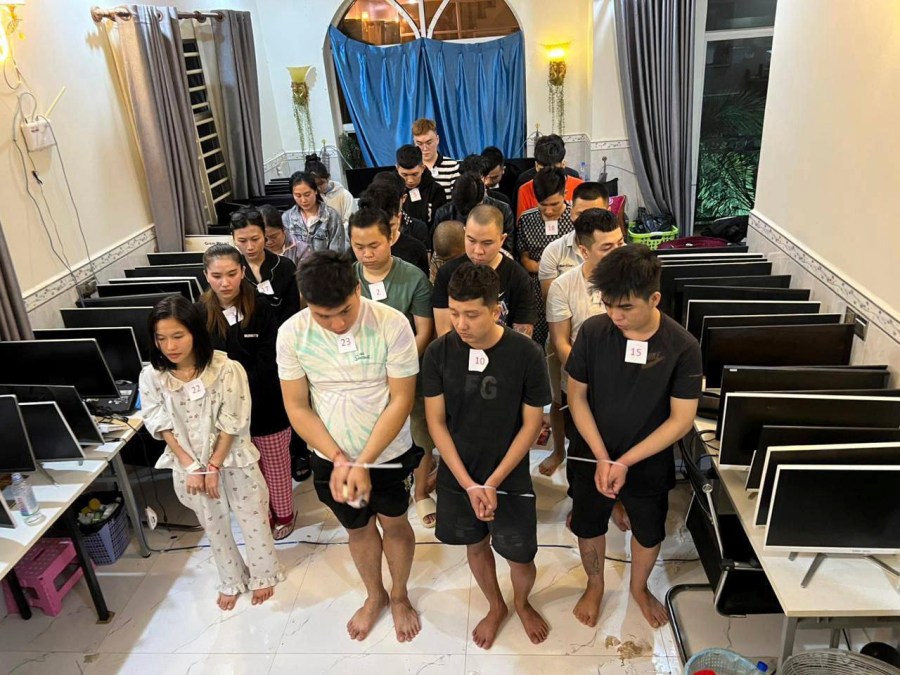 In this photo released by Agence Kampuchea Press (AKP), online scammers arrested by authorities stand in a building in Sihanoukville province, southwestern of Phnom Penh, Cambodia, Tuesday, July 15, 2025. (AKP via AP)