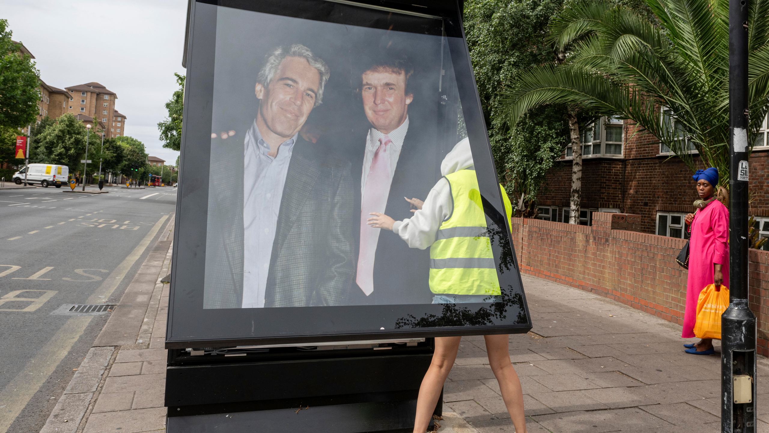 Activists put up a poster showing President Donald Trump and Jeffrey Epstein near the U.S. Embassy in London, Thursday, July 17, 2025.(AP Photo/Thomas Krych)