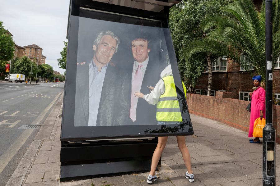 Activists put up a poster showing President Donald Trump and Jeffrey Epstein near the U.S. Embassy in London, Thursday, July 17, 2025.(AP Photo/Thomas Krych)