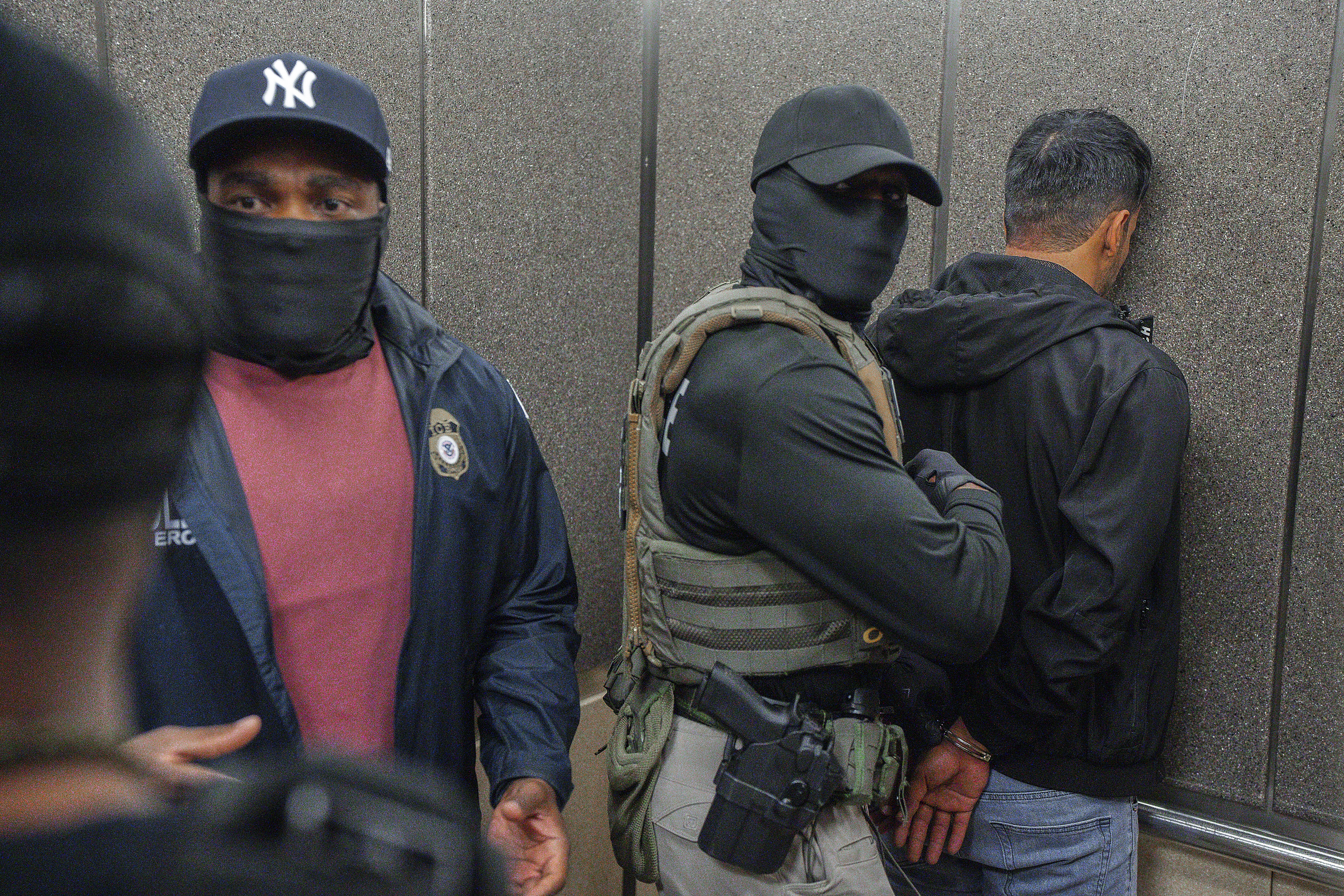 FILE - Immigration and Customs Enforcement agents escort a detained immigrant into an elevator after he exited an immigration courtroom, Tuesday, June 17, 2025, in New York. (AP Photo/Olga Fedorova, file)