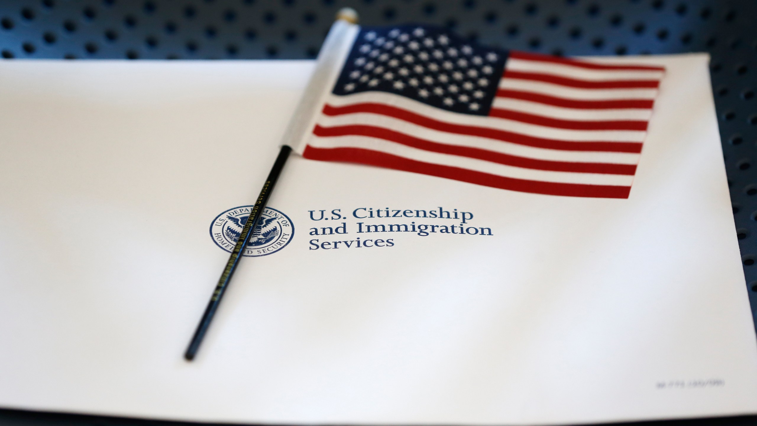 FILE - An information packet and an American flag are placed on a chair at the U.S. Citizenship and Immigration Services Miami Field Office on Aug. 17, 2018, in Miami. (AP Photo/Wilfredo Lee, File)