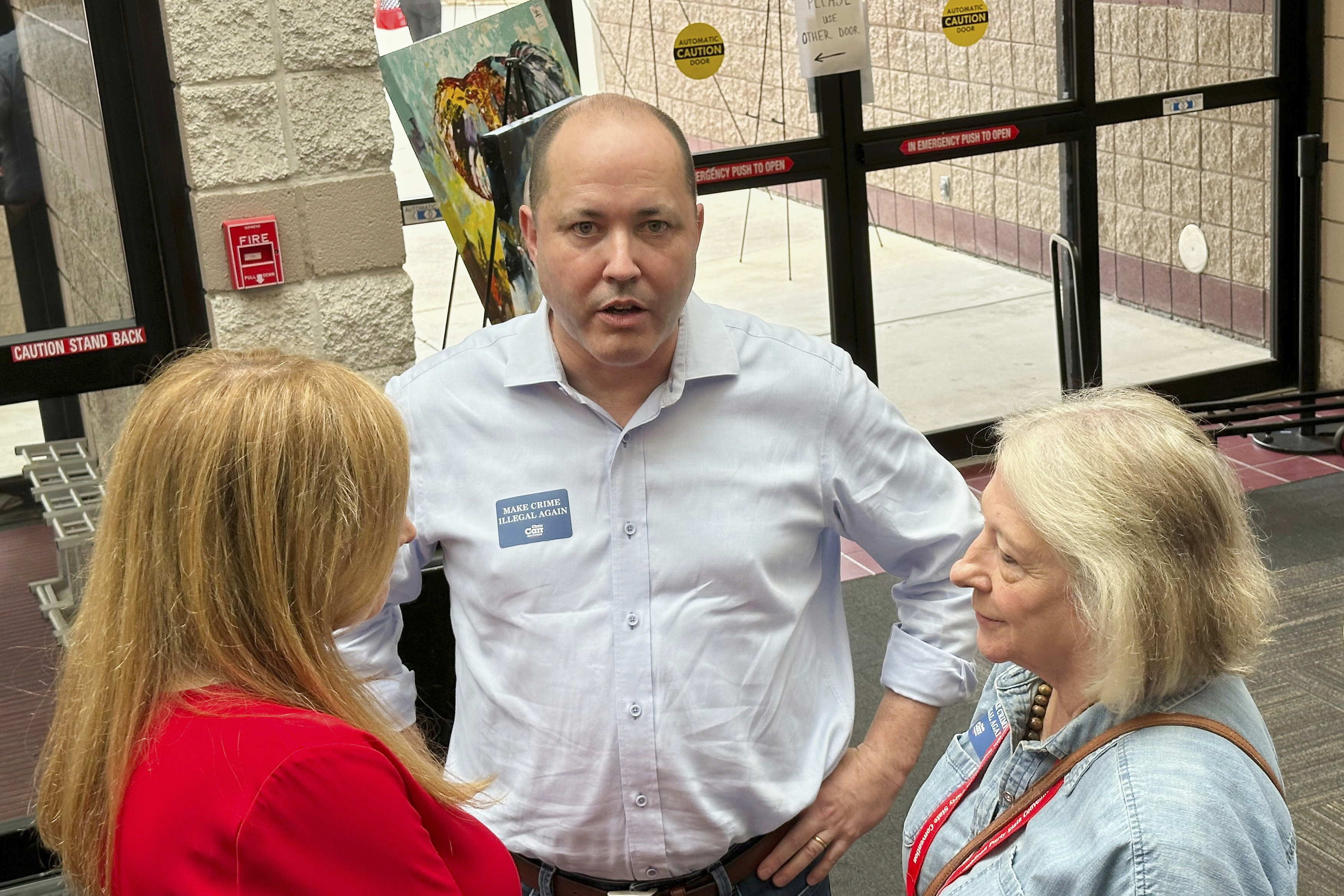 FILE - Georgia Attorney General Chris Carr, center, speaks to a delegate at the Georgia Republican Convention in Dalton, Ga., Friday, June 6, 2025. (AP Photo/Jeff Amy, File)