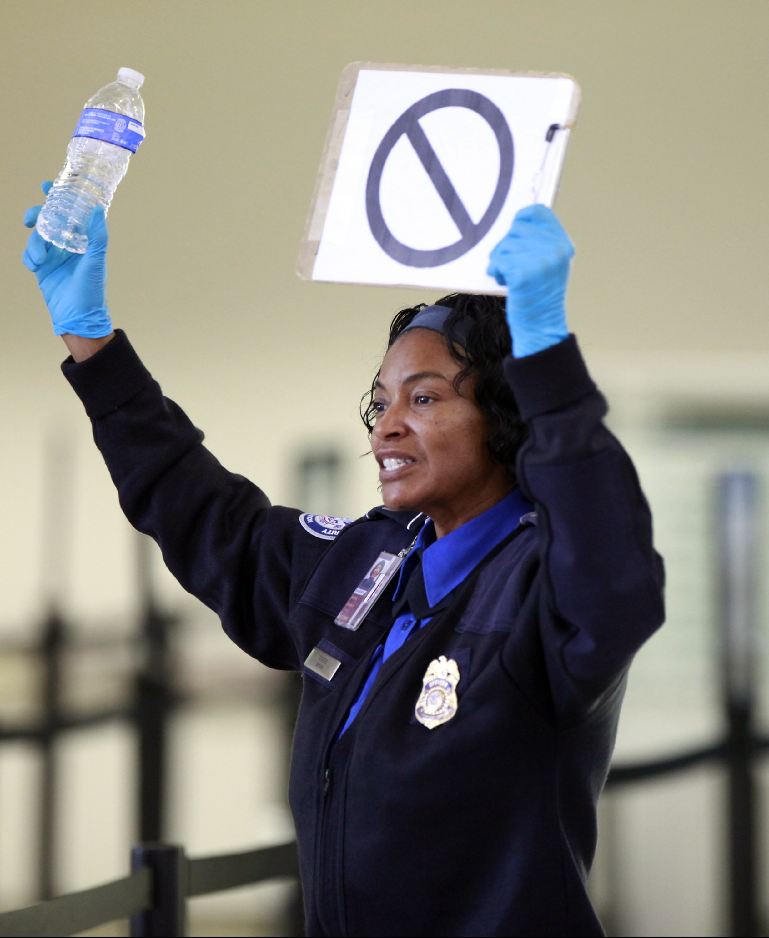 FILE - A TSA employee advises travelers that liquids are not allowed through the gate at at the Los Angeles International Airport, Oct. 10, 2012. (AP Photo/Damian Dovarganes, File)