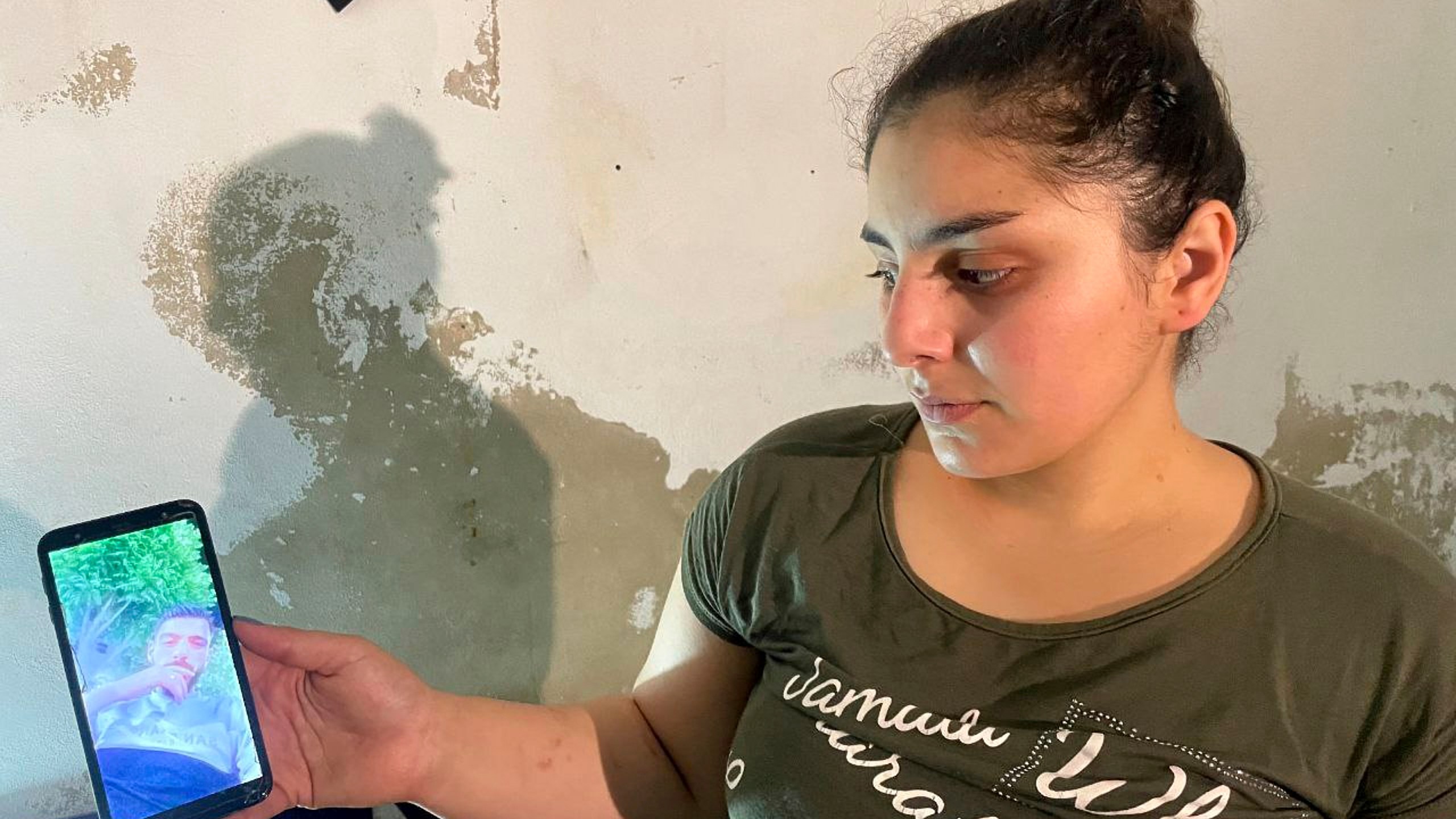 Druze woman, Evelyn Azzam, 20, shows a picture of her husband who was wounded in clashes between Syrian government forces and Druze militias in Sweida, during an interview with The Associated Press in the southern Damascus suburb of Jaramana, Wednesday, July 16, 2025. (AP Photo/Abdulrahman Shaheen)
