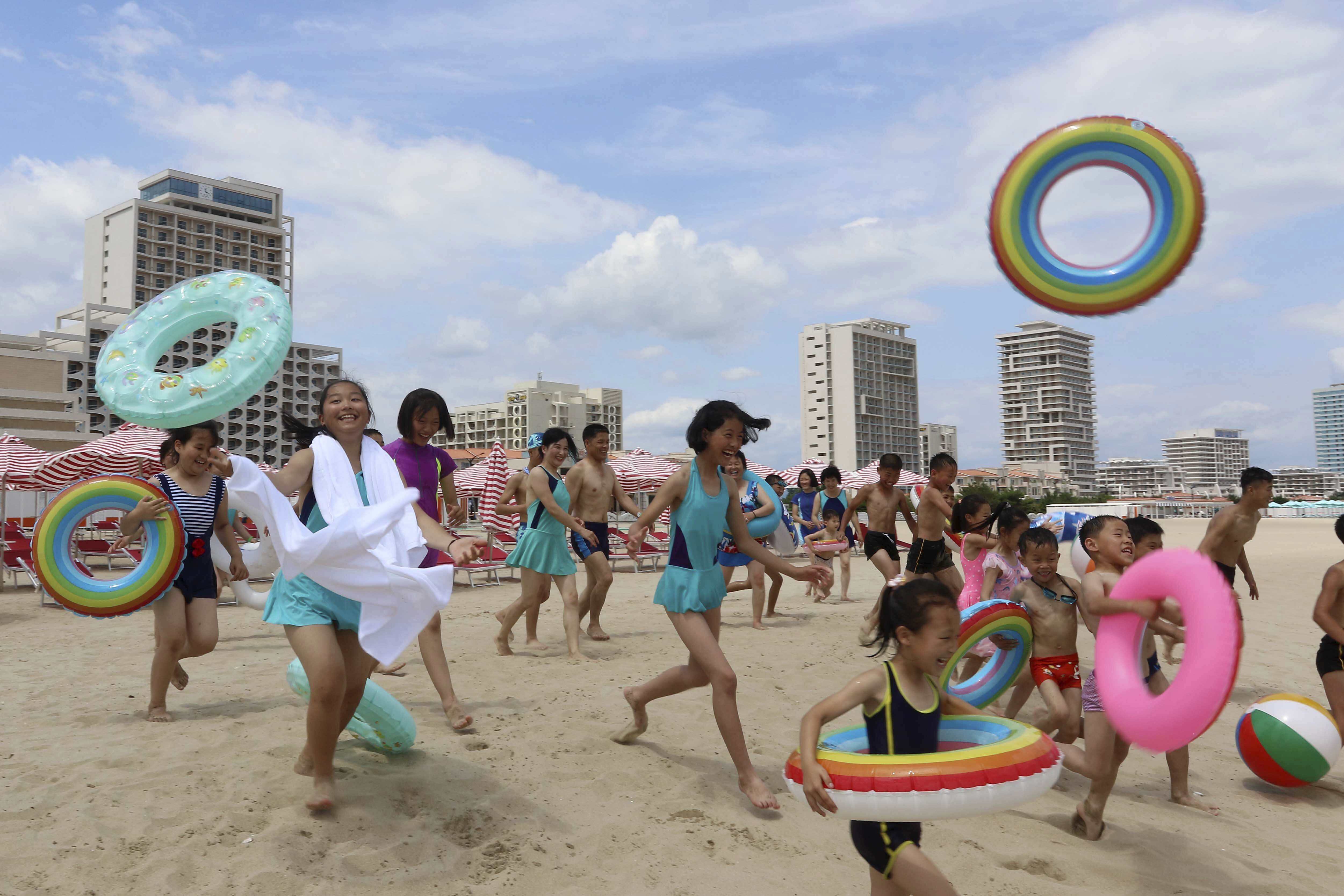 Children run into sea at the Wonsan-Kalma resort in Wonsan, Kangwon Province, North Korea, Wednesday, July 2, 2025. (AP Photo/Jon Chol Jin)