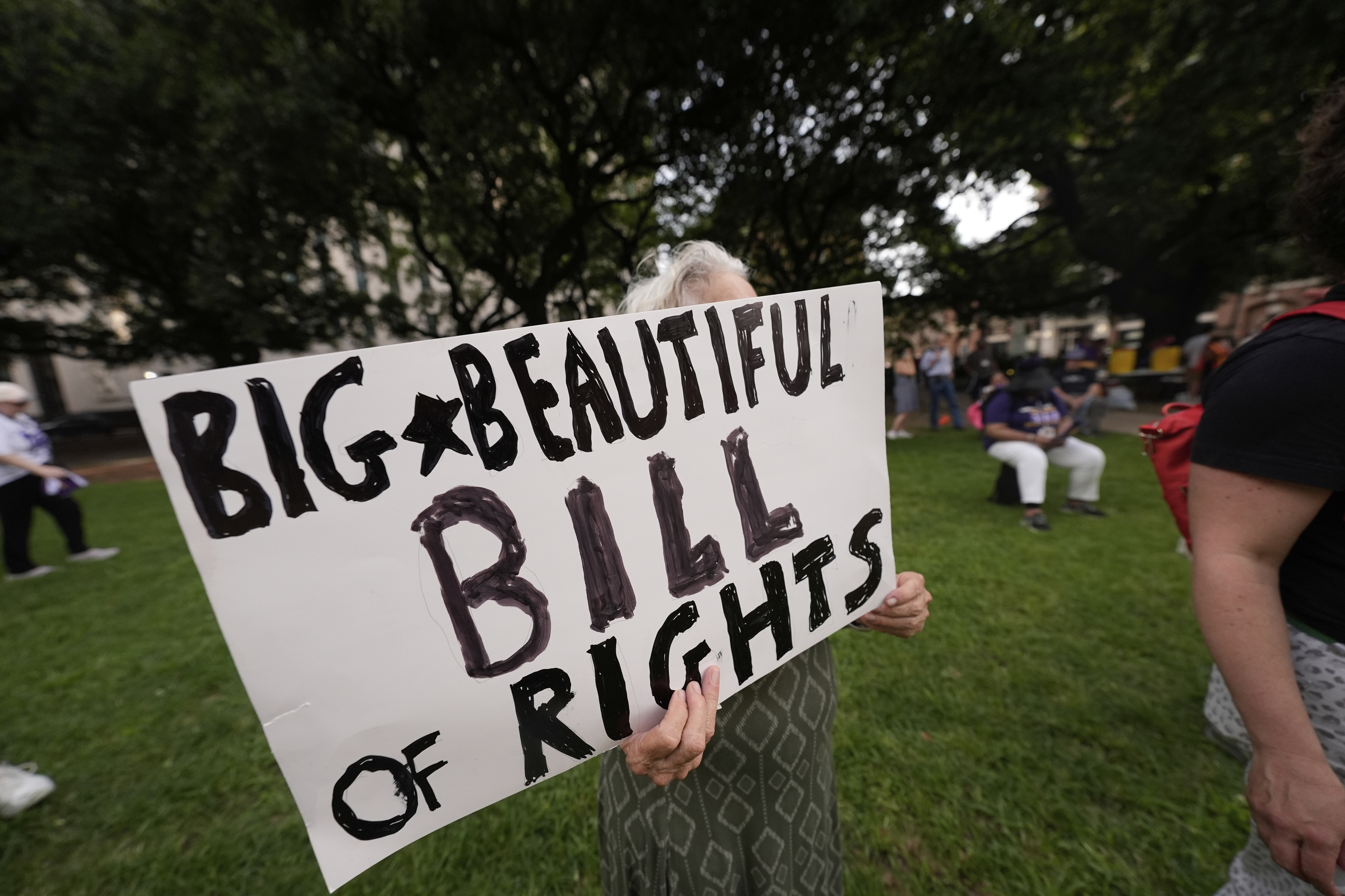 FILE - A protestor holds a sign during a demonstration in New Orleans, July 1, 2025. (AP Photo/Gerald Herbert, File)