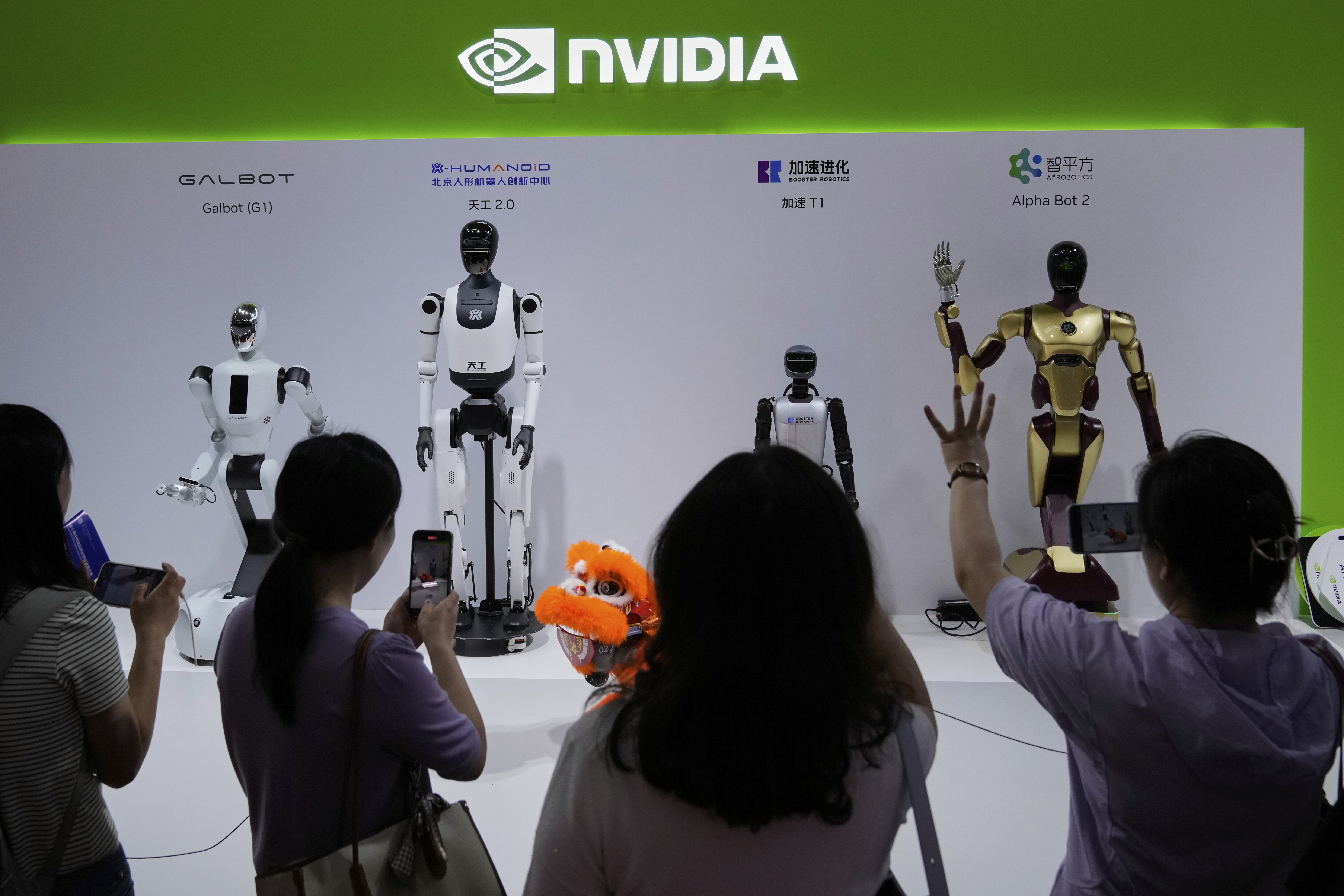 Visitors give commands to a robot at Nvidia's booth during the 3rd China International Supply Chain Expo at the China International Exhibition Center, in Beijing, China, Friday, July 18, 2025. (AP Photo/Mahesh Kumar A.)
