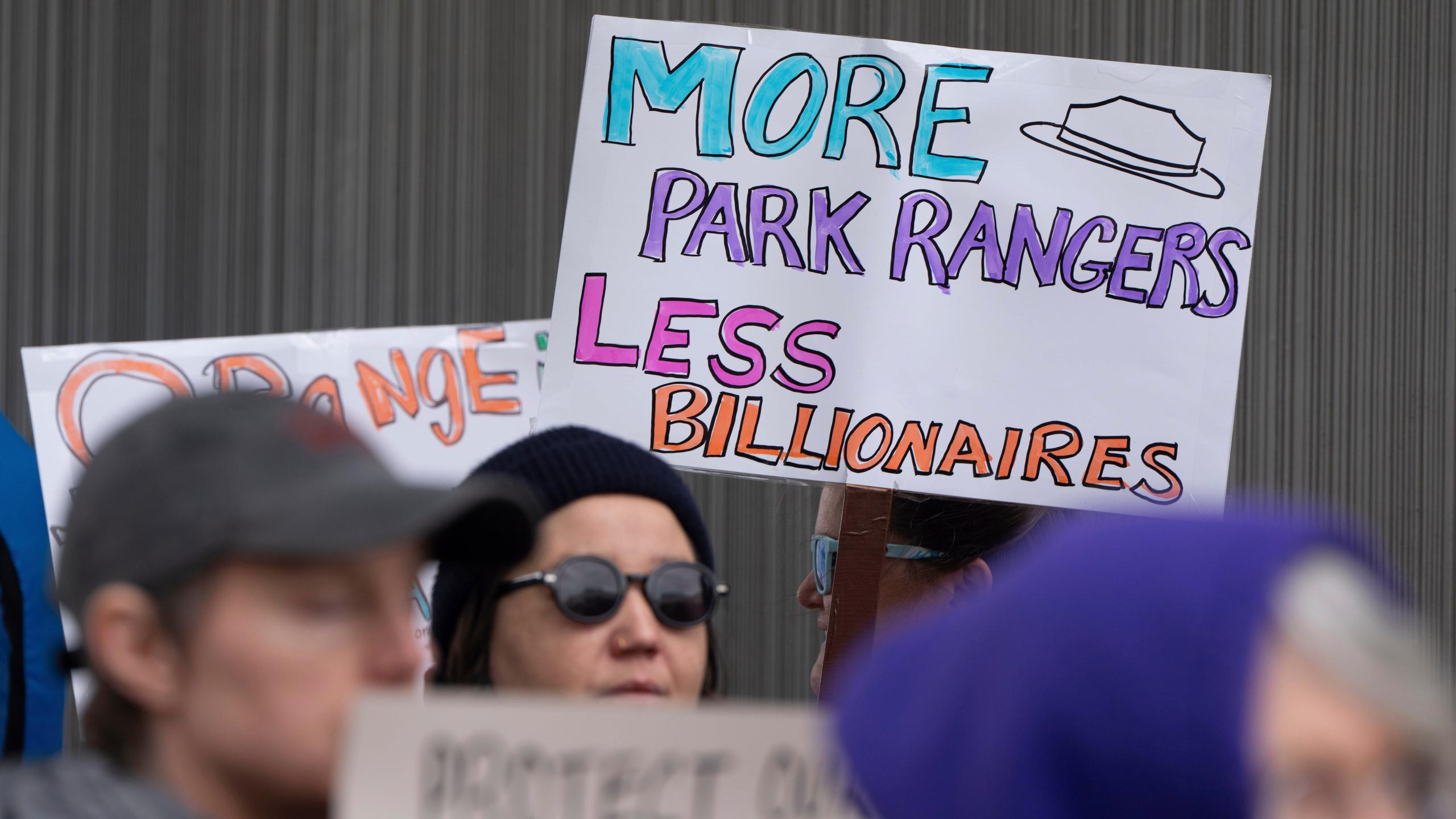 FILE - People hold signs during a protest outside the annual Alaska Sustainable Energy Conference, June 3, 2025, in Anchorage, Alaska. (AP Photo/Jenny Kane, File)