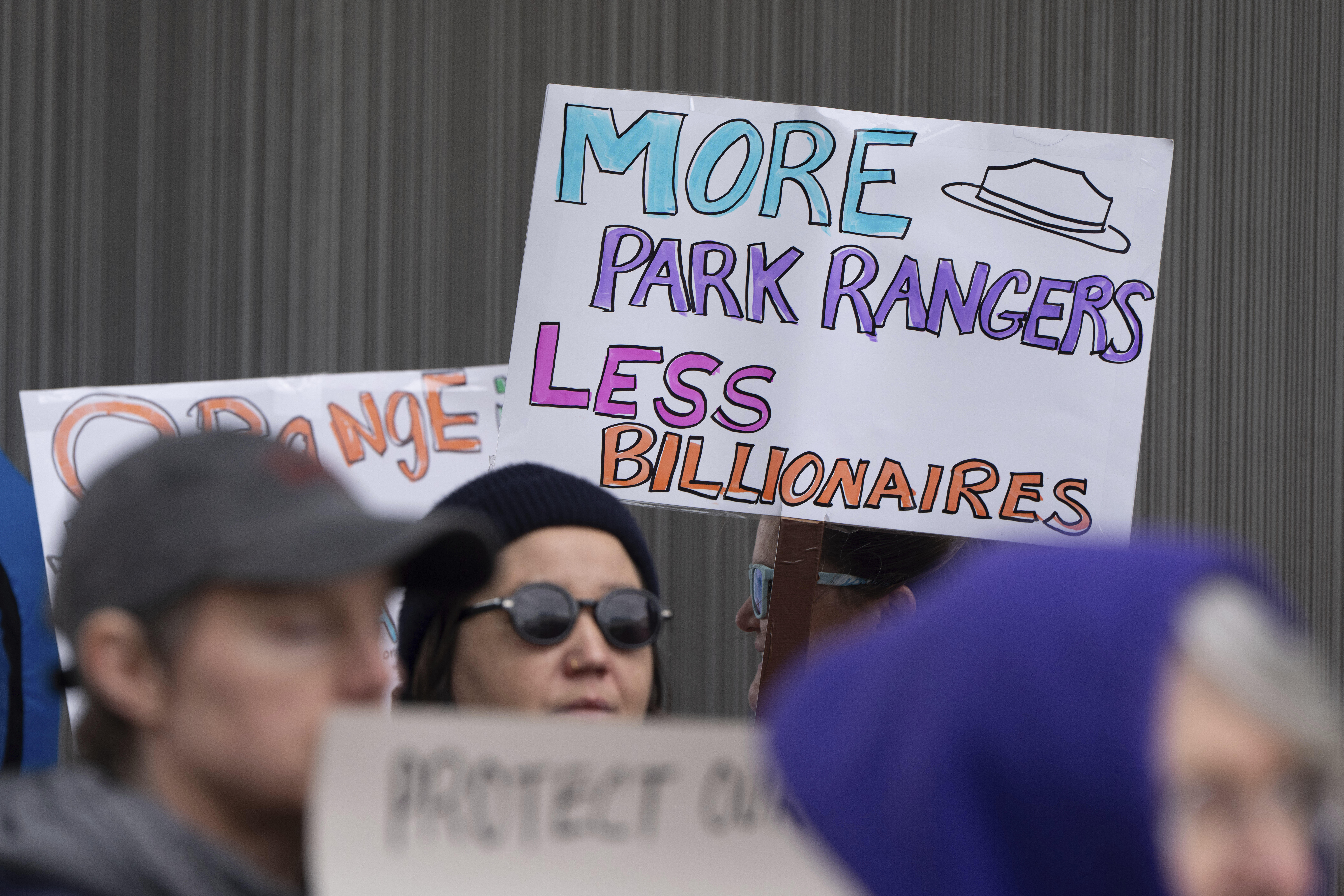 FILE - People hold signs during a protest outside the annual Alaska Sustainable Energy Conference, June 3, 2025, in Anchorage, Alaska. (AP Photo/Jenny Kane, File)