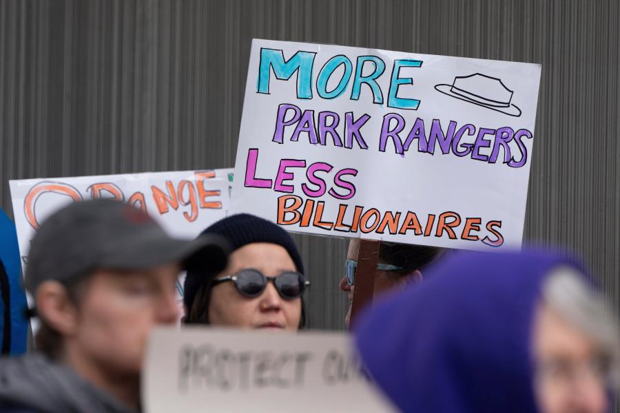 FILE - People hold signs during a protest outside the annual Alaska Sustainable Energy Conference, June 3, 2025, in Anchorage, Alaska. (AP Photo/Jenny Kane, File)