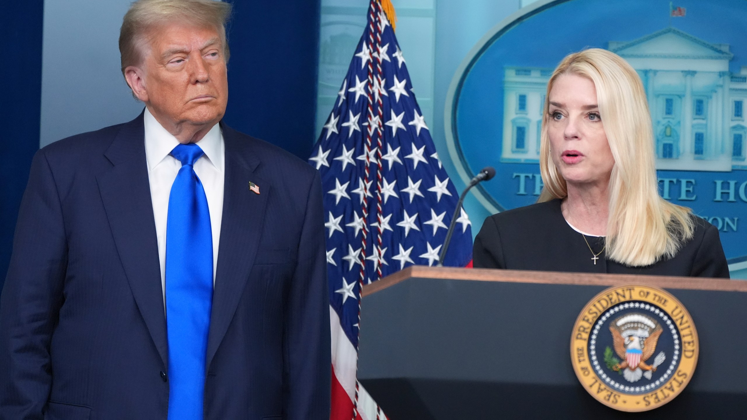 Attorney General Pam Bondi speaks to reporters as President Donald Trump listens, Friday, June 27, 2025, in the briefing room of the White House in Washington. (AP Photo/Jacquelyn Martin)