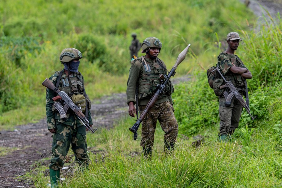 FILE - M23 rebels stand with their weapons in Kibumba, in the eastern of Democratic Republic of Congo, Dec. 23, 2022. (AP Photo/Moses Sawasawa, File)