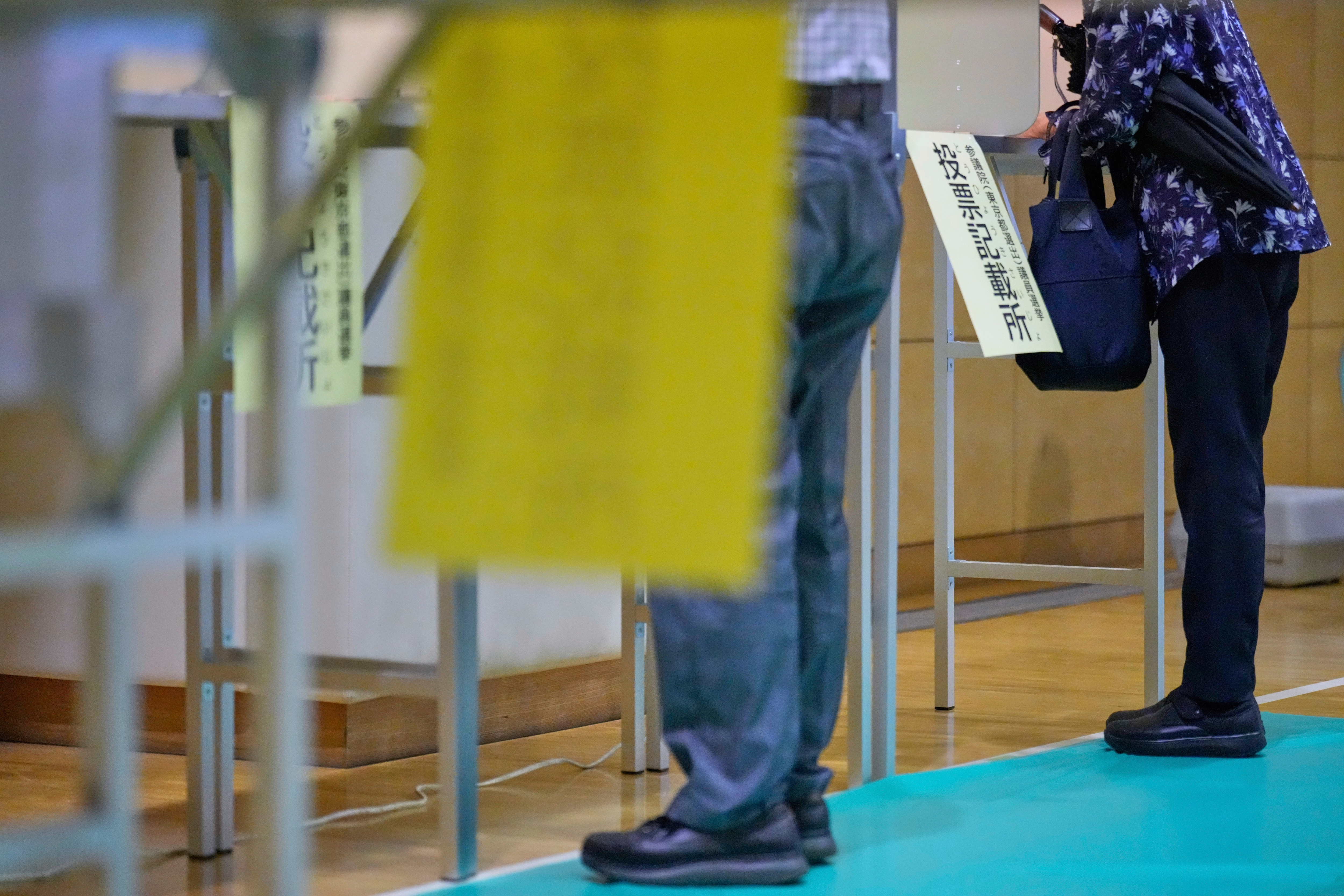 Voters fill in their ballots in the upper house election at a polling station Sunday, July 20, 2025, in Tokyo. (AP Photo/Eugene Hoshiko)