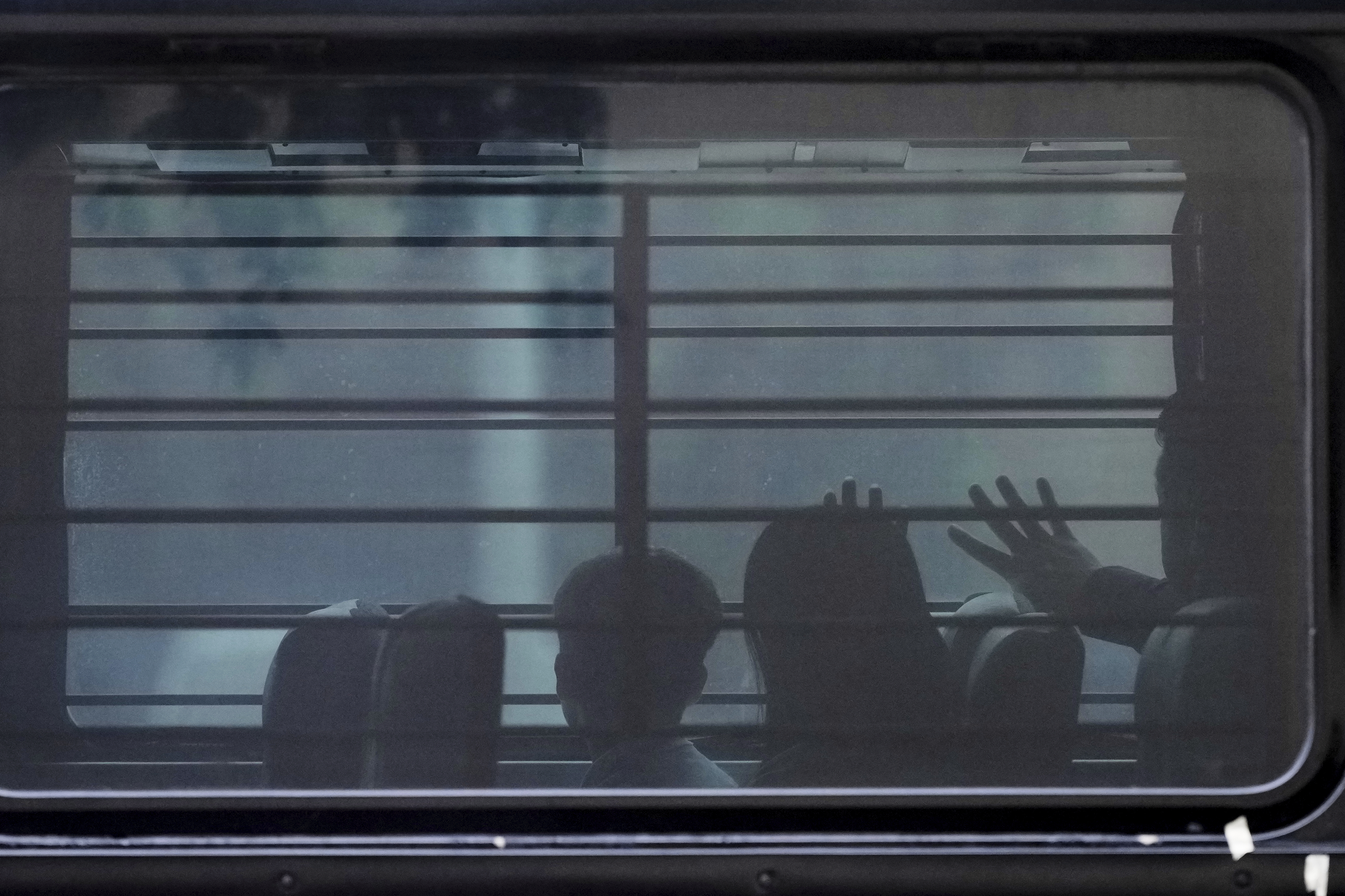 FILE - A family from Cuba is detained and loaded on to a bus with tinted windows and bars following an appearance at immigration court, June 11, 2025, in San Antonio. (AP Photo/Eric Gay, File)