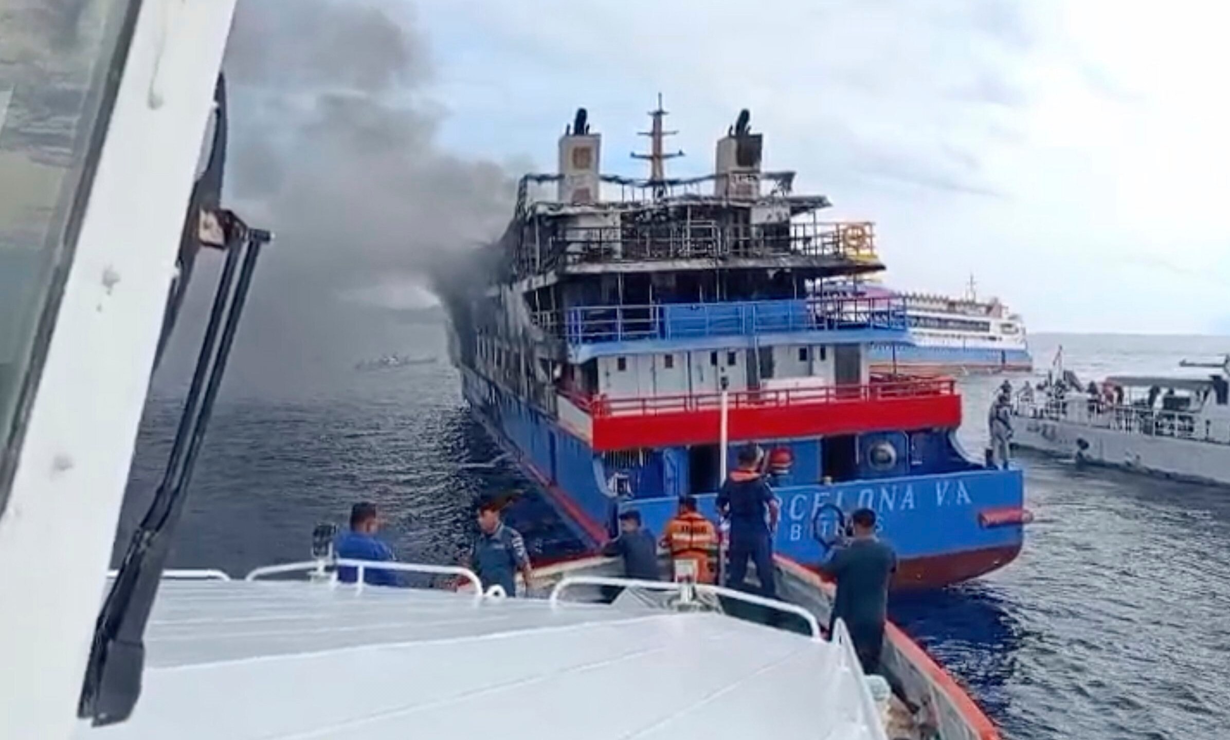 In this photo made from video released by the Indonesian National Search and Rescue Agency (BASARNAS), rescue ship approach passenger ship KM Barcelona after it caught fire in the waters off Talise Island in North Sulawesi, Indonesia, Sunday, July 20, 2025. (BASARNAS via AP)