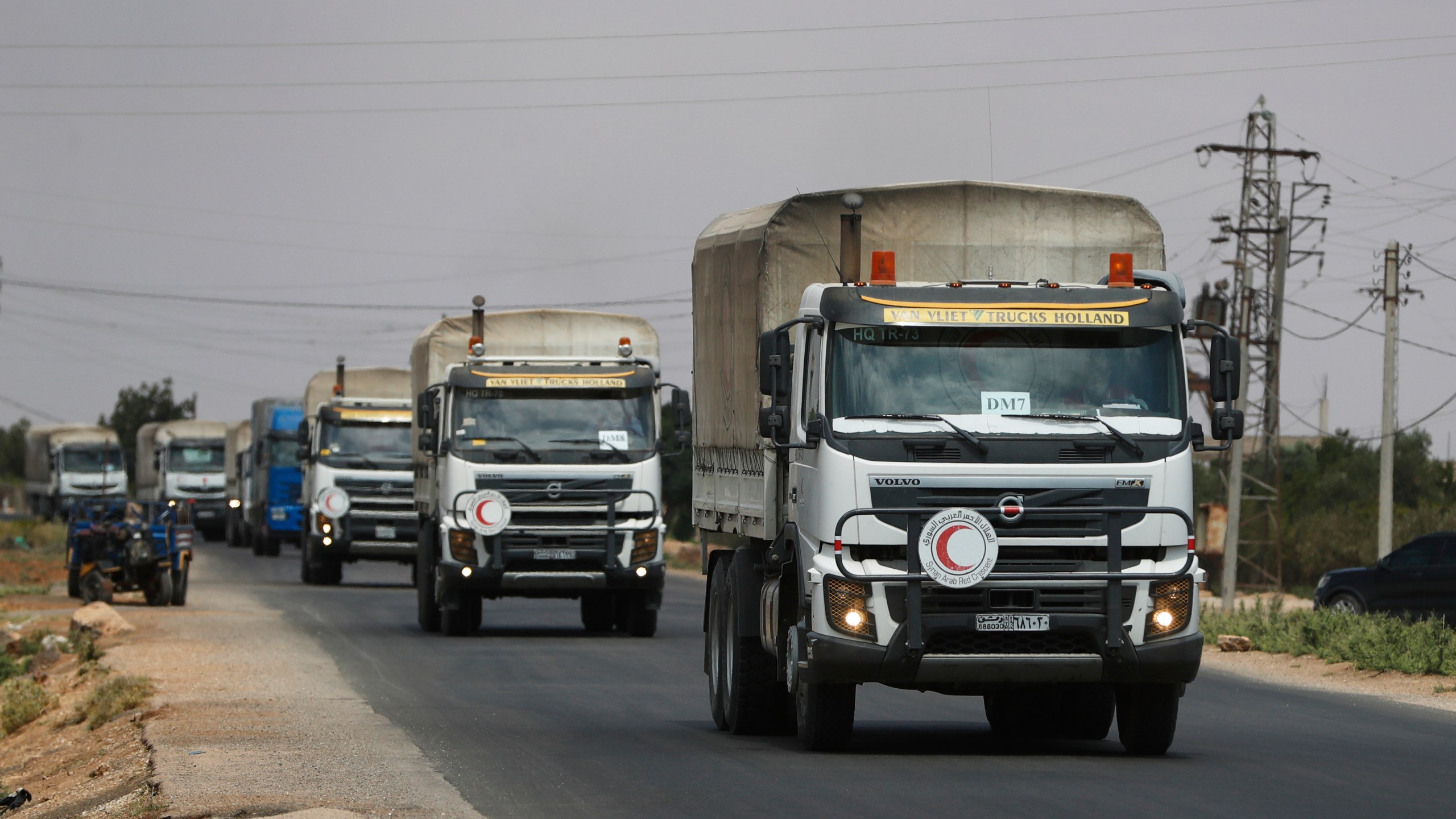A convoy of vehicles loaded with food and other aid is en route to Sweida on the international highway in rural Daraa province, Syria, Sunday, July 20, 2025, heading to the city of Busra al-Sham. (AP Photo/Omar Sanadiki)