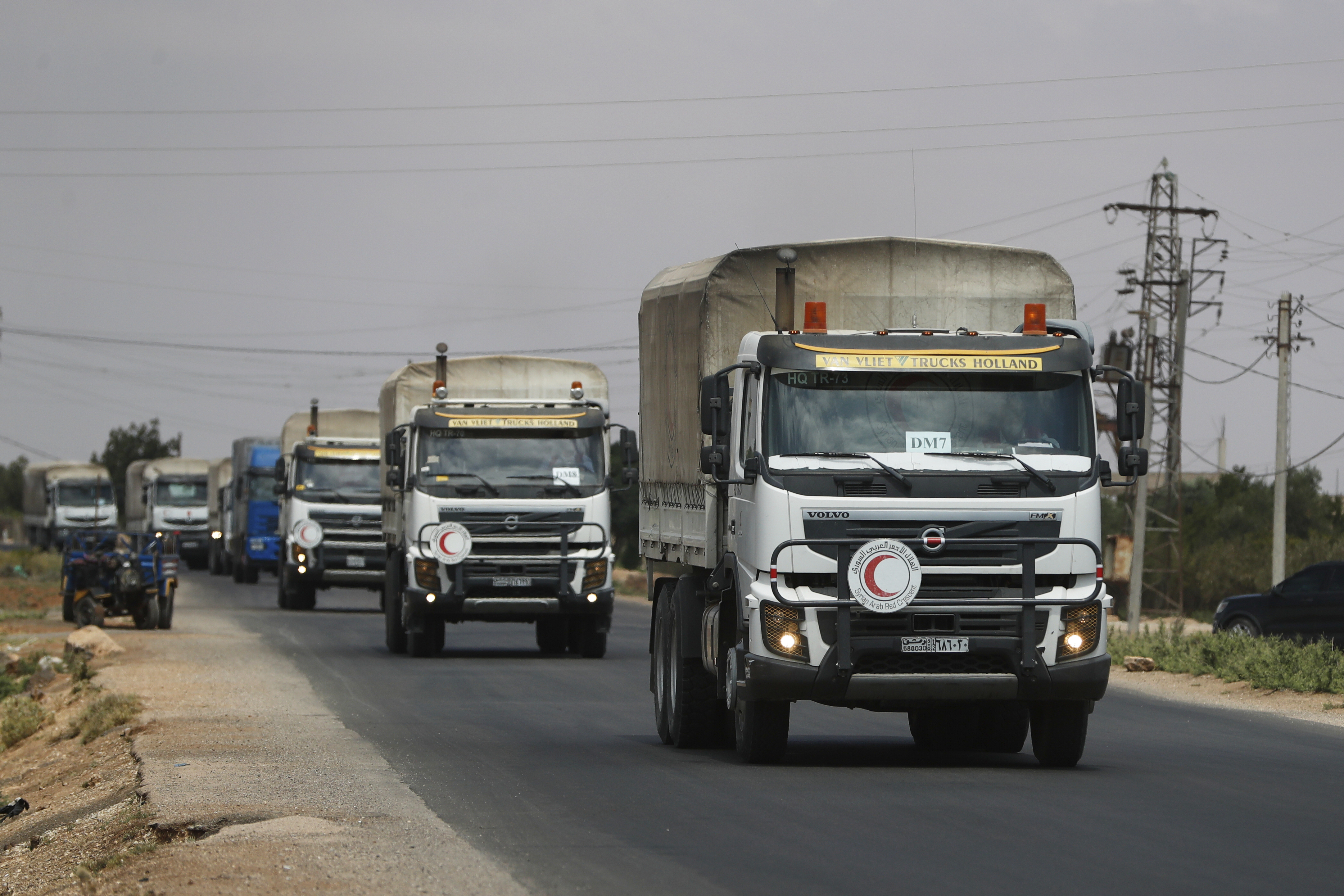A convoy of vehicles loaded with food and other aid is en route to Sweida on the international highway in rural Daraa province, Syria, Sunday, July 20, 2025, heading to the city of Busra al-Sham. (AP Photo/Omar Sanadiki)