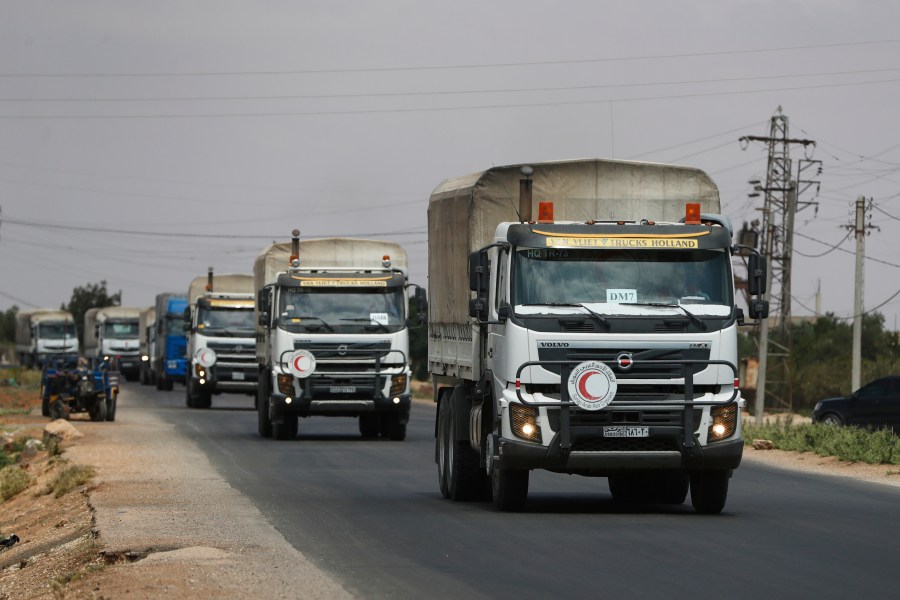 A convoy of vehicles loaded with food and other aid is en route to Sweida on the international highway in rural Daraa province, Syria, Sunday, July 20, 2025, heading to the city of Busra al-Sham. (AP Photo/Omar Sanadiki)