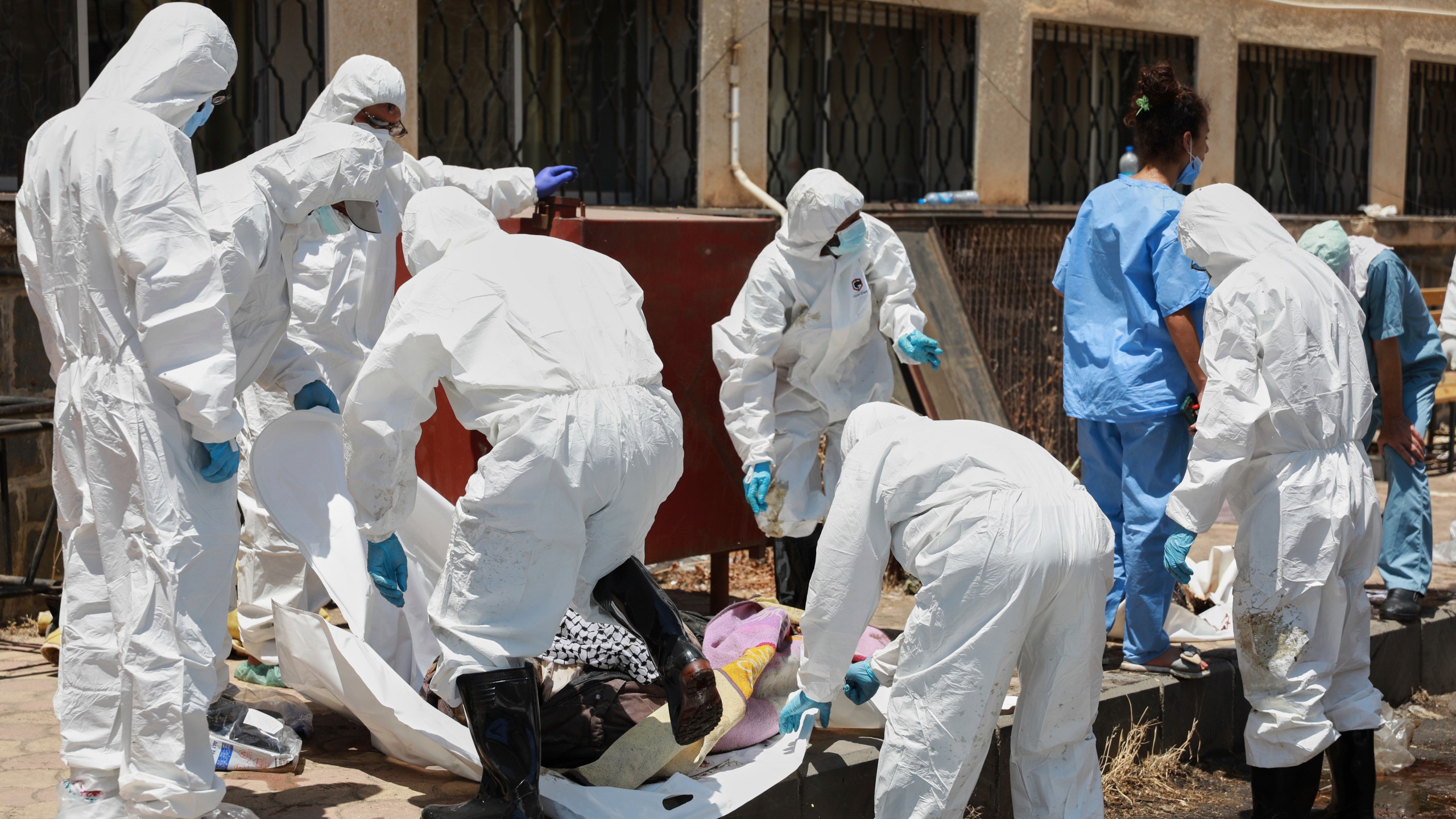 Morgue workers place the bodies of unidentified people killed during clashes between Bedouin clans and Druze militias, into plastic bags outside the National Hospital in Sweida, Syria, Monday, July 21, 2025. (AP Photo/Fahd Kiwan)