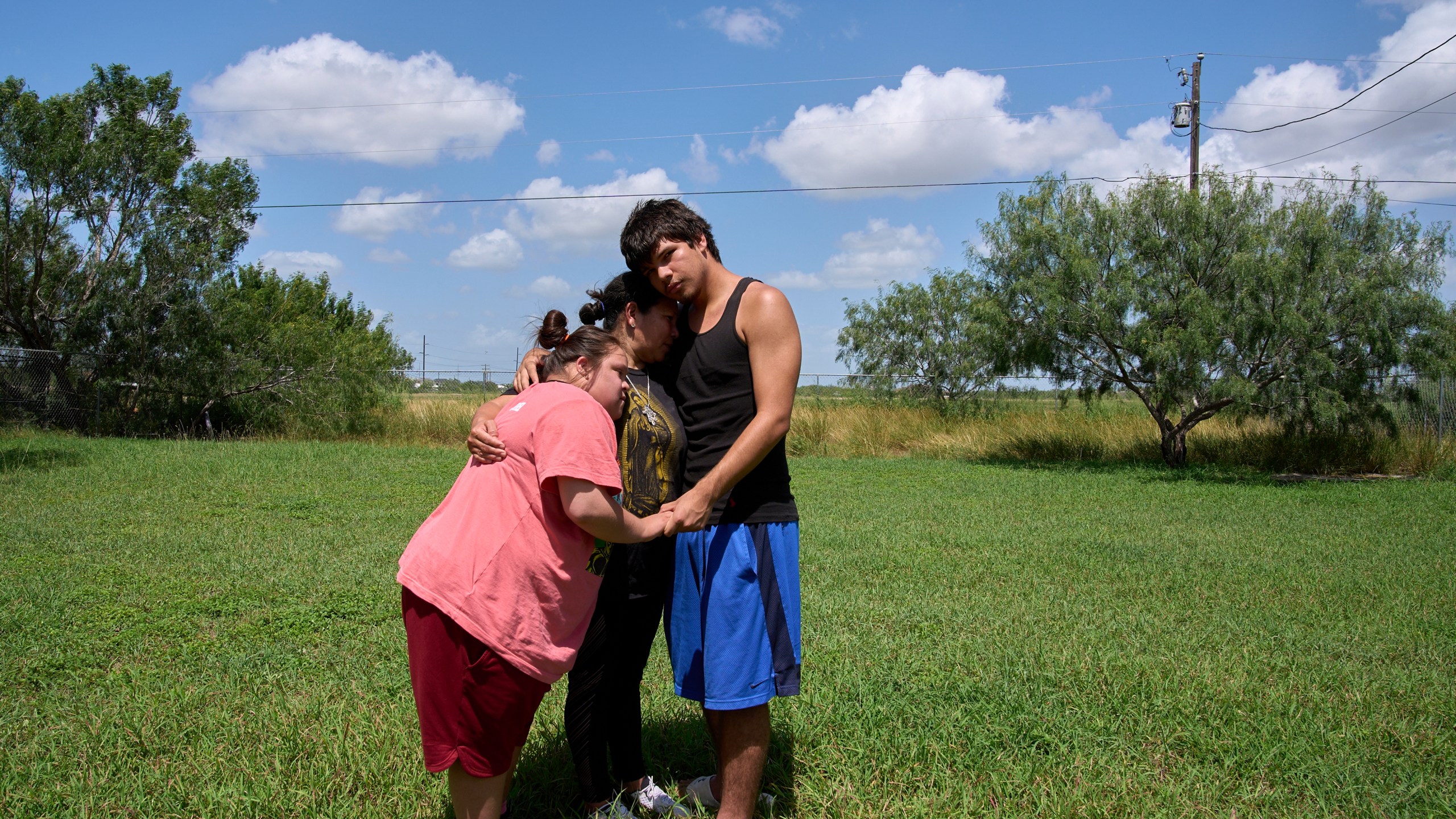 Juanita is hugged by her children, Jose, 15, and daughter Marely, 17, who has Down syndrome, Tuesday, June 17, 2025, during a portrait in Hidalgo County, Texas. (AP Photo/Jacquelyn Martin)