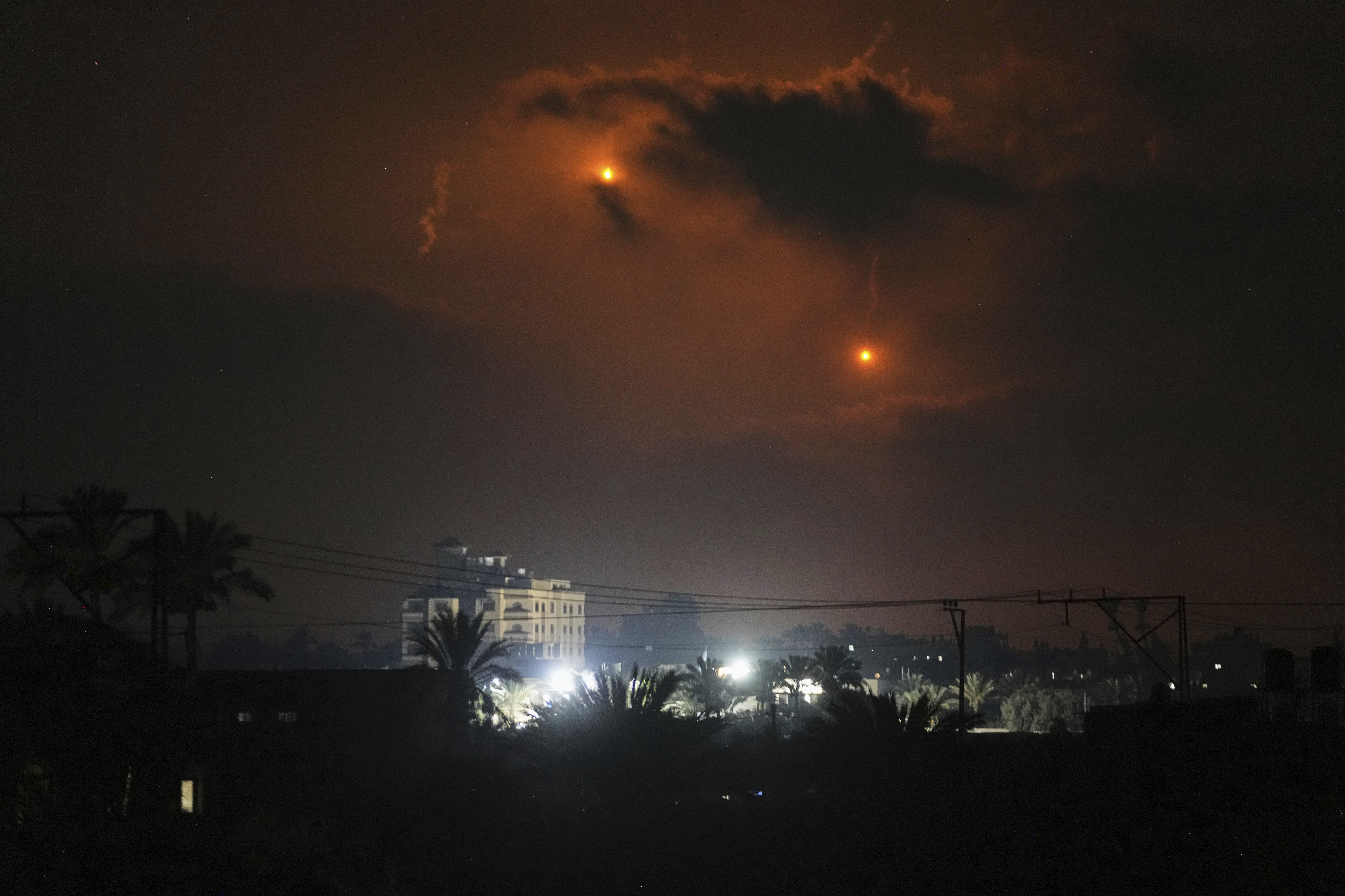 Illumination flares launched by the Israeli army are seen over Deir al-Balah in central Gaza Strip Monday, July 21, 2025. (AP Photo/Abdel Kareem Hana)