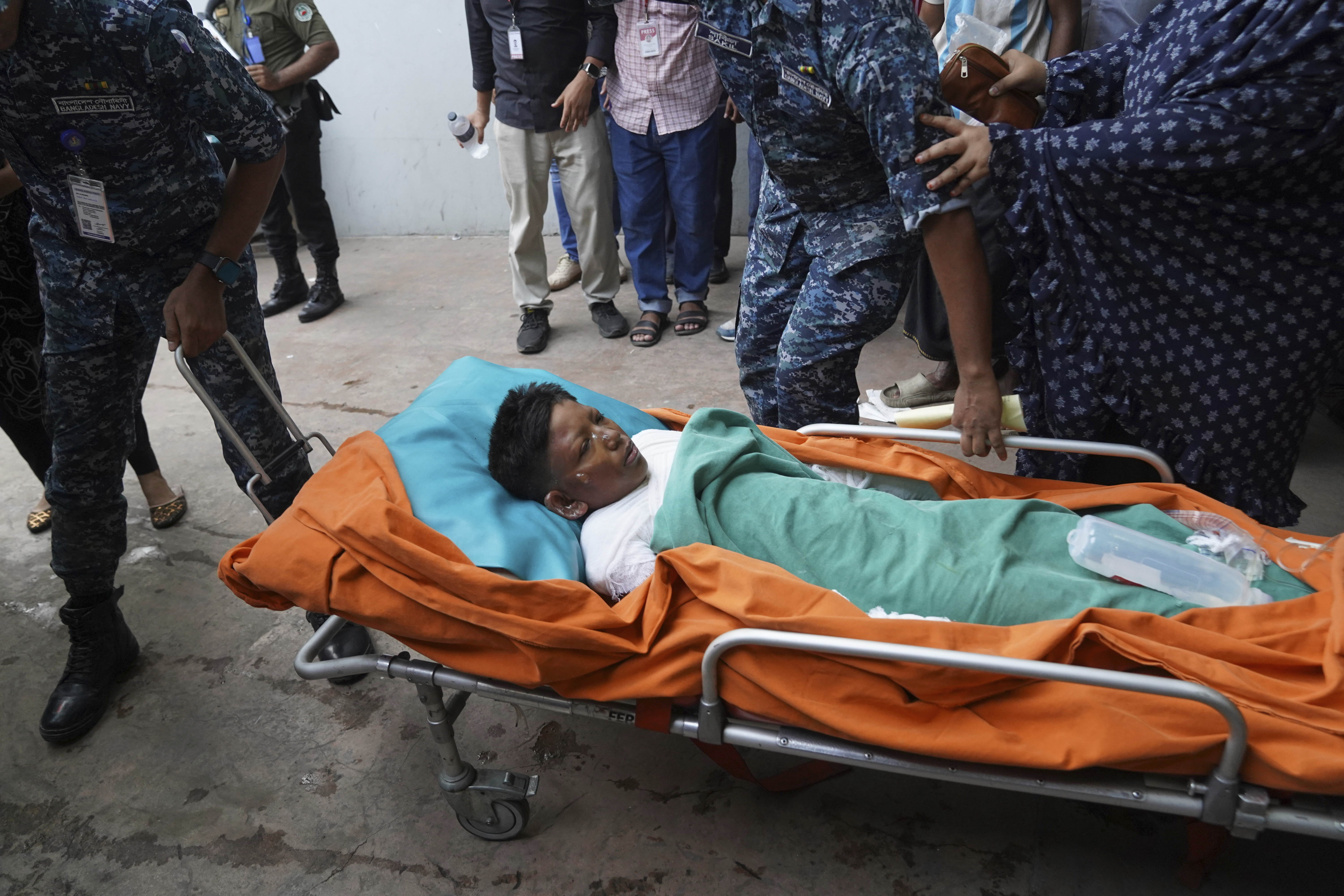 An injured victim in the Bangladesh Air Force aircraft crash lies on a stretcher at a hospital in Dhaka, Bangladesh, Monday, July 21, 2025. (AP Photo/Ahadul Karim Khan)