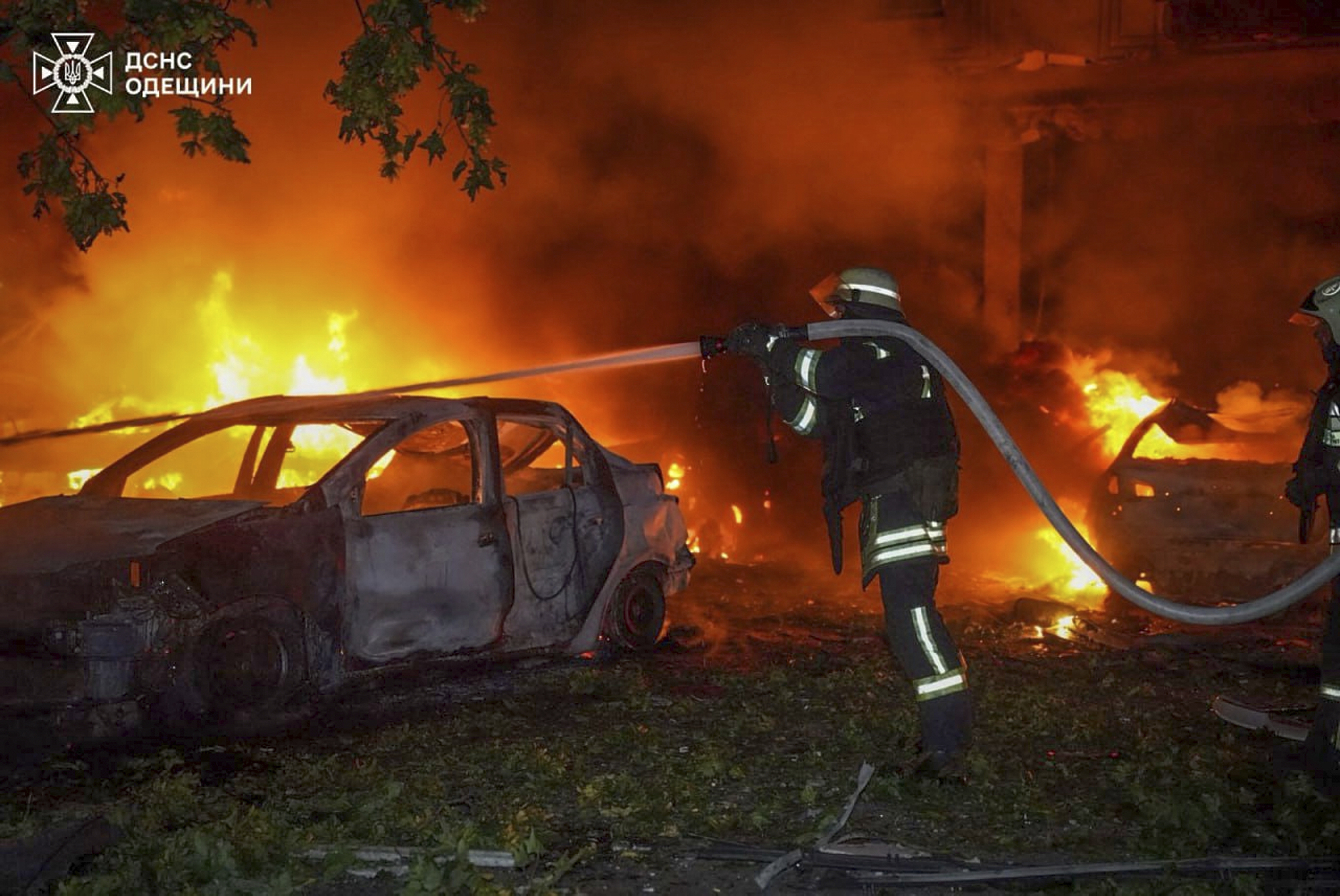 In this photo provided by the Ukrainian Emergency Service, emergency services personnel work to extinguish a fire following a Russian attack in Odesa, Ukraine, Tuesday, July 22, 2025. (Ukrainian Emergency Service via AP)